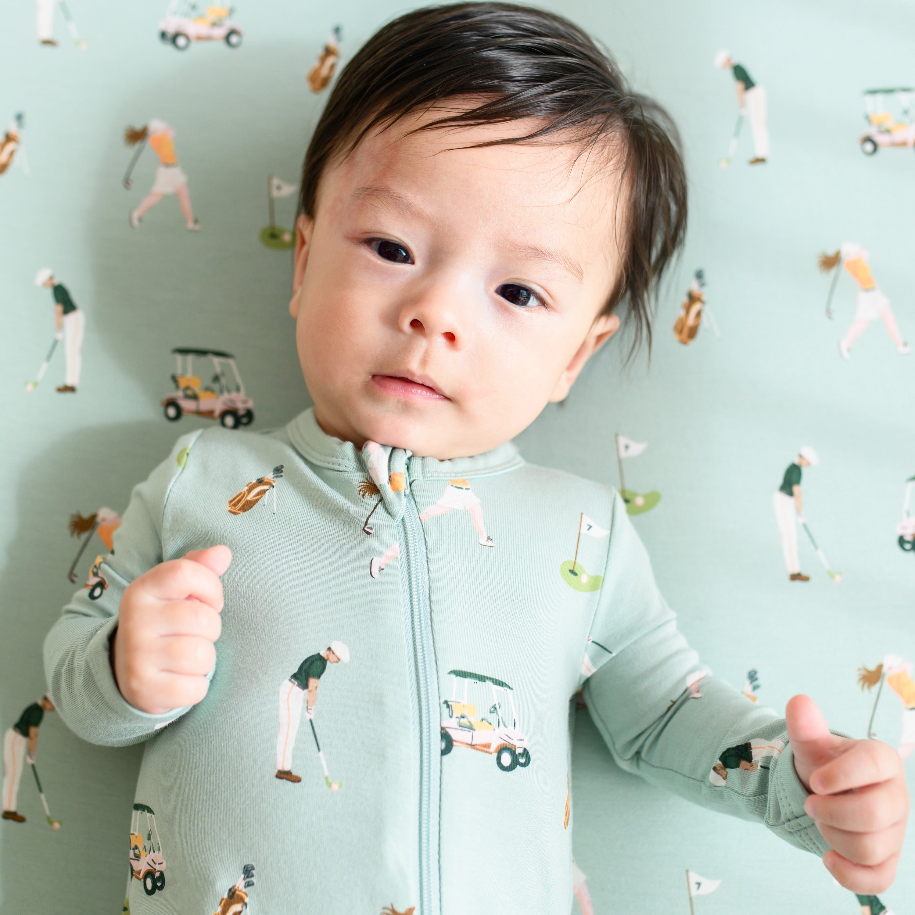 Infant wearing Kyte Baby Zippered Romper pajamas in Golf