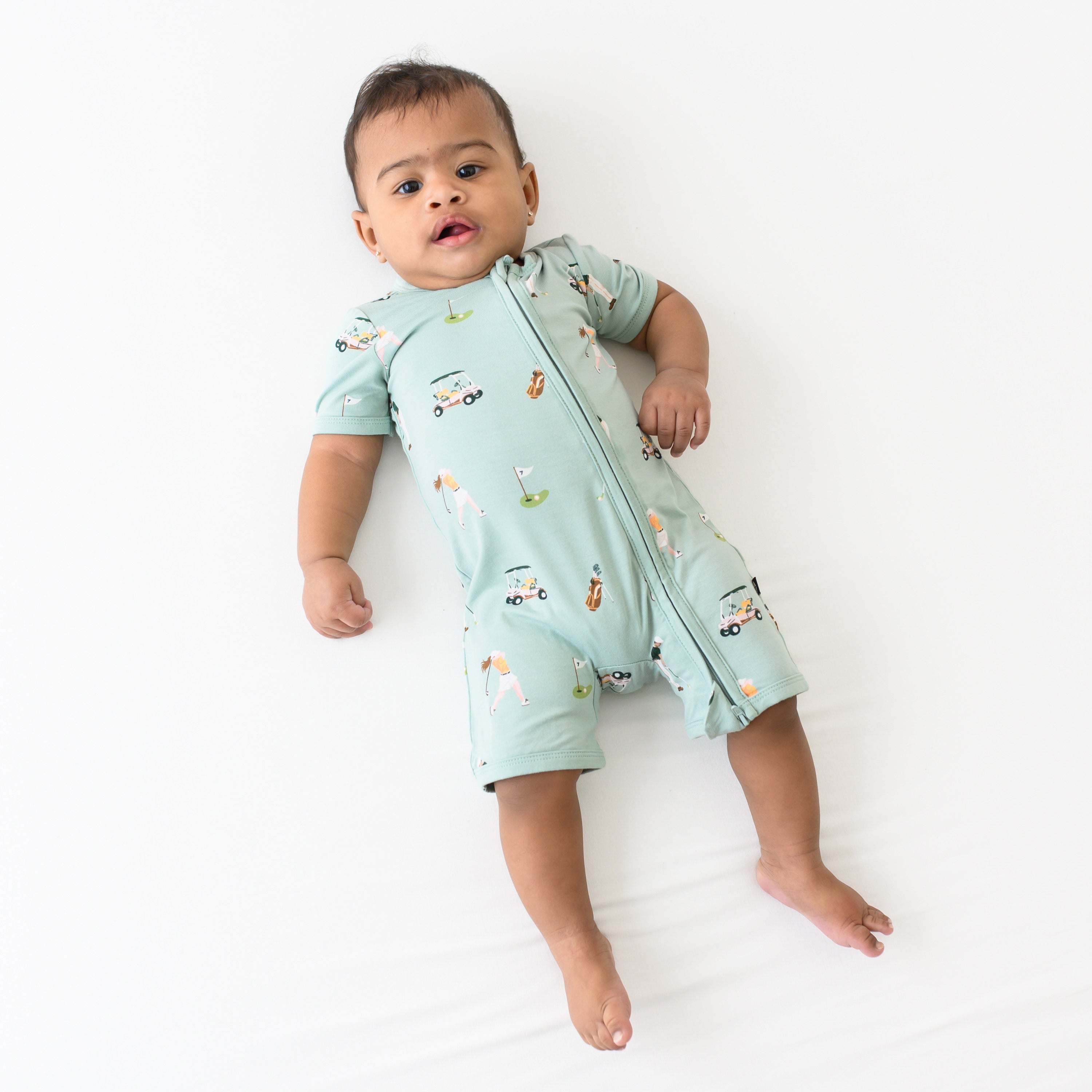 Infant wearing Kyte Baby Zippered Shortall Romper in Golf