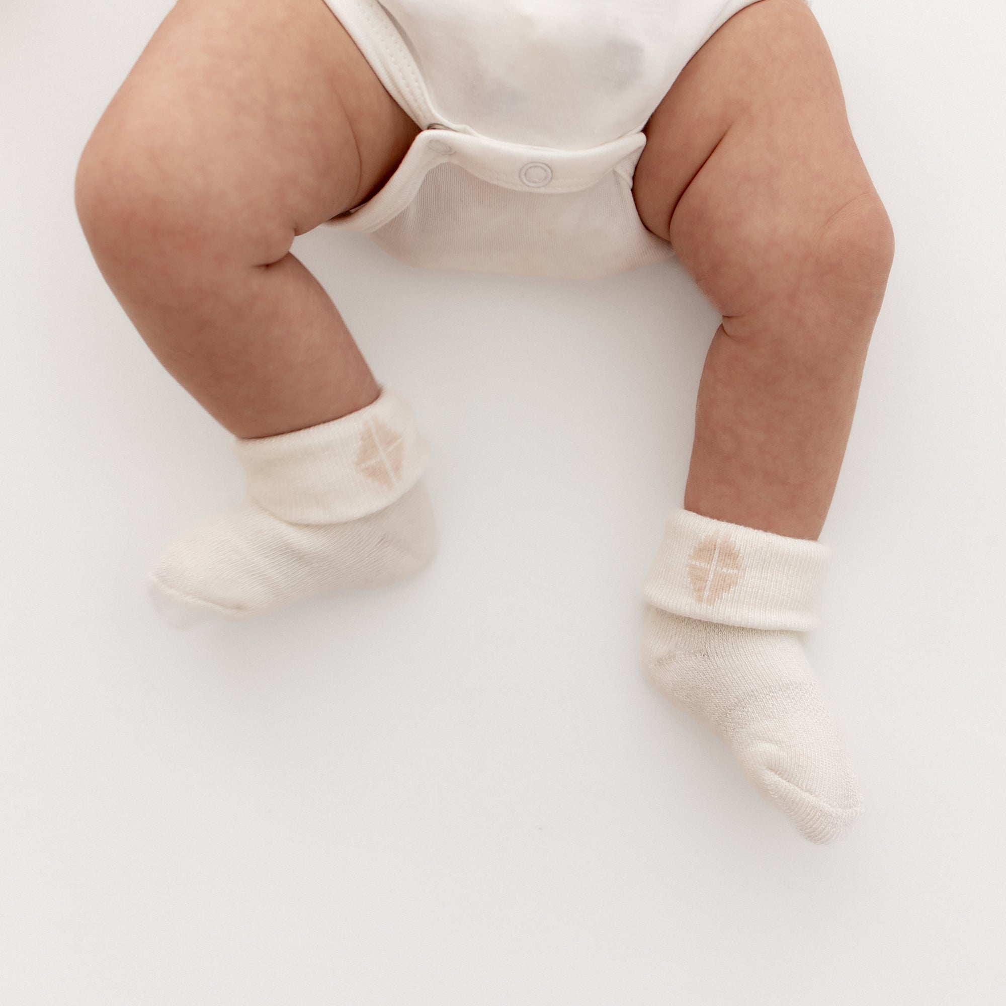 Baby wearing plush infant socks in white