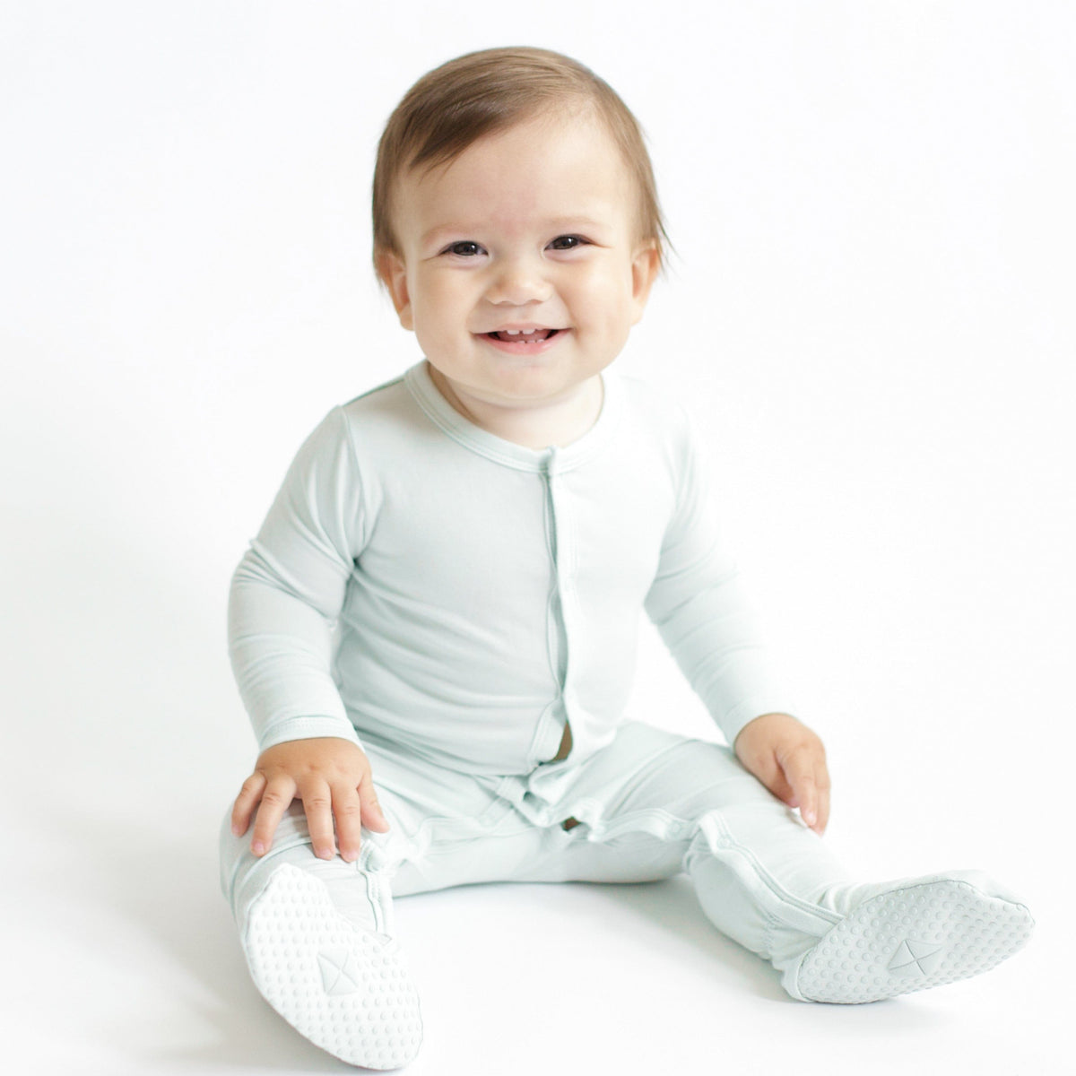Smiling infant sitting wearing the Footie in Dew
