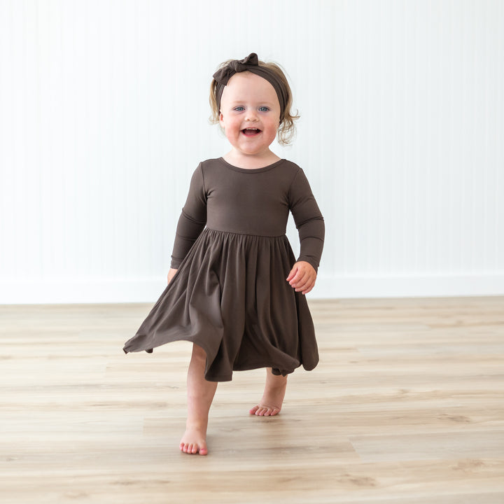 Toddler girl walking wearing the Women's Jogger Pajama Set in Espresso with matching knotted bow headband