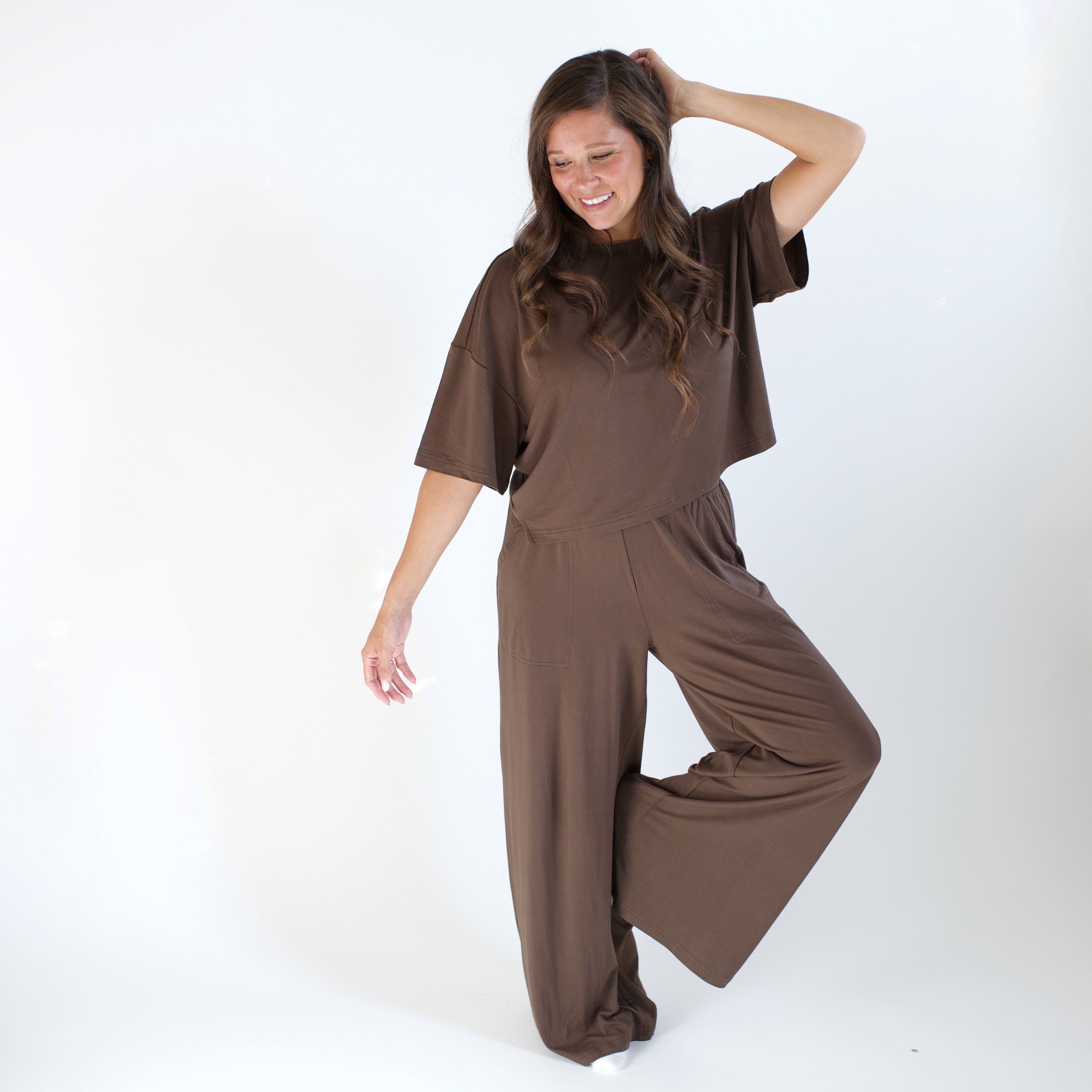 Woman wearing brown outfit with a boxy top and wide leg pant