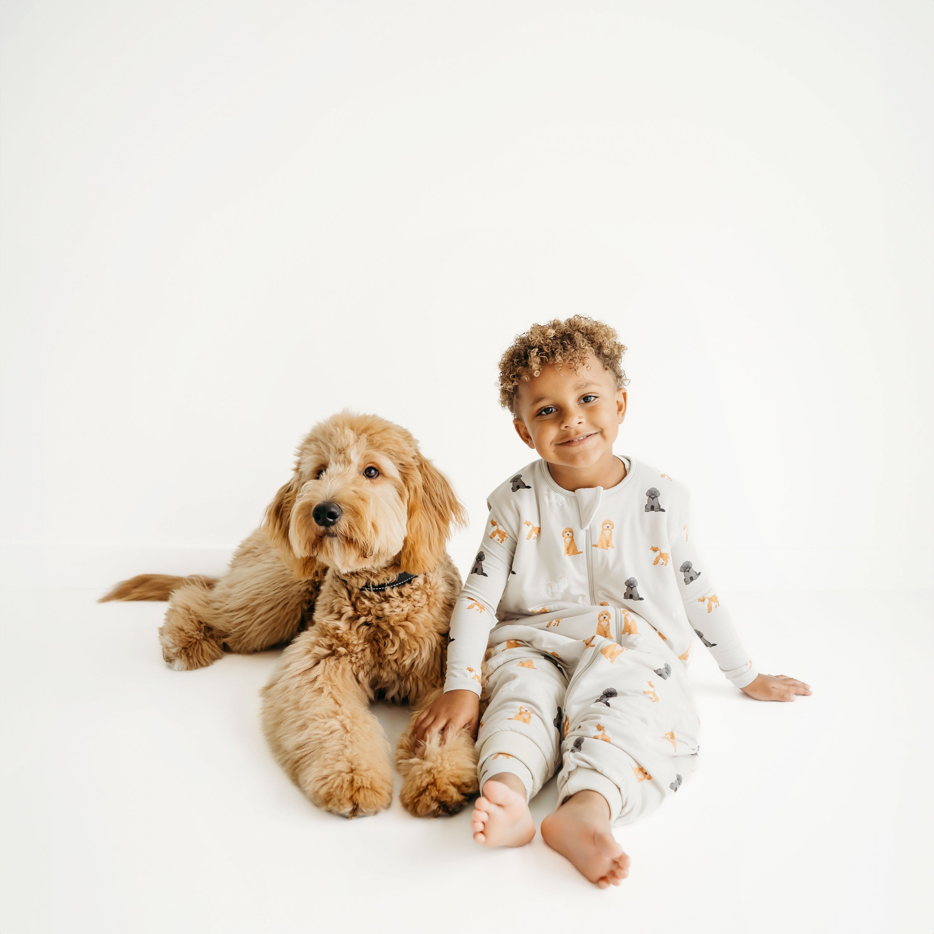 Child sitting and wearing Sleep Bag Walker in Fluffy Dog 1.0 next to a real dog