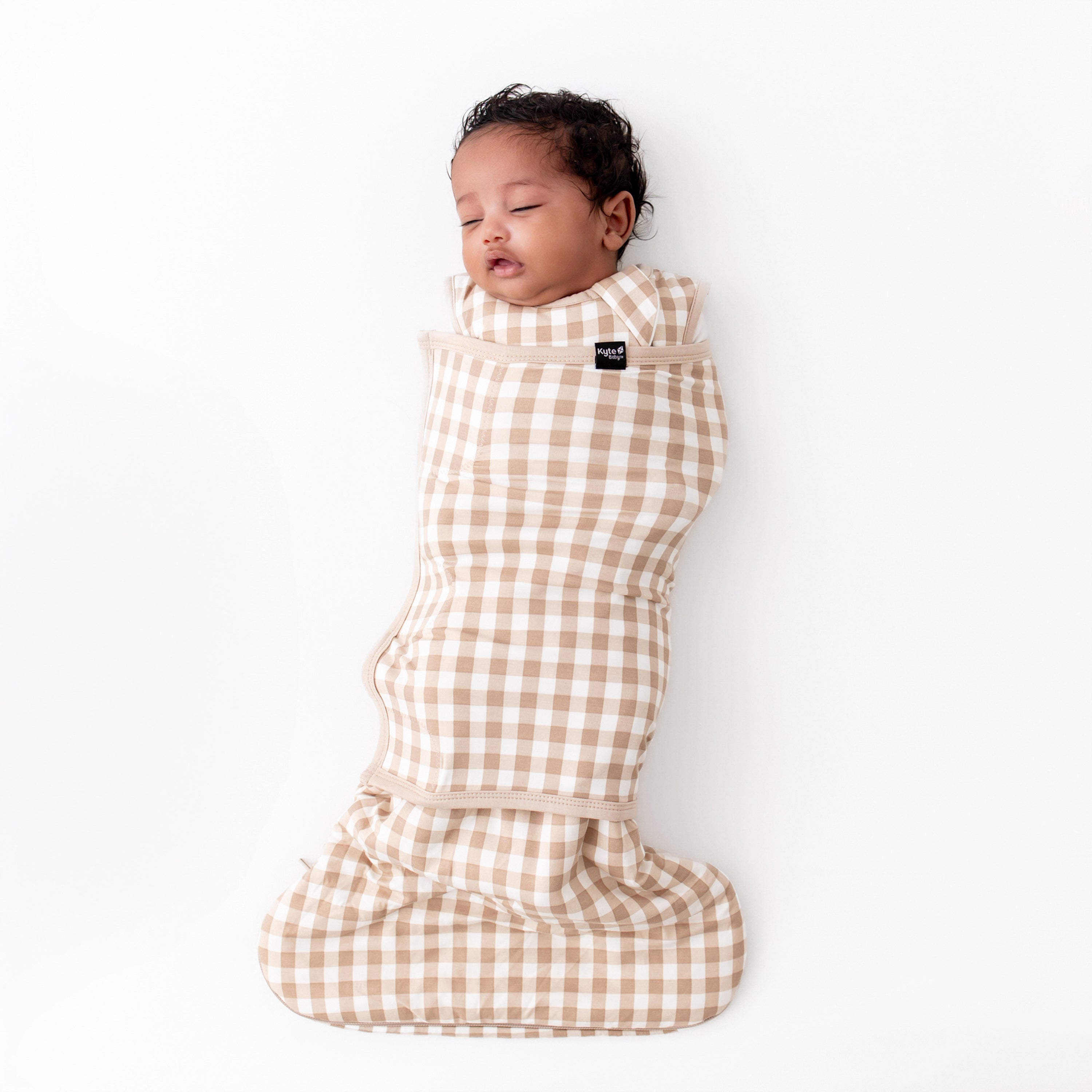 Infant sleeping in the Sleep Bag Swaddler in Gingham Bisque 1.0