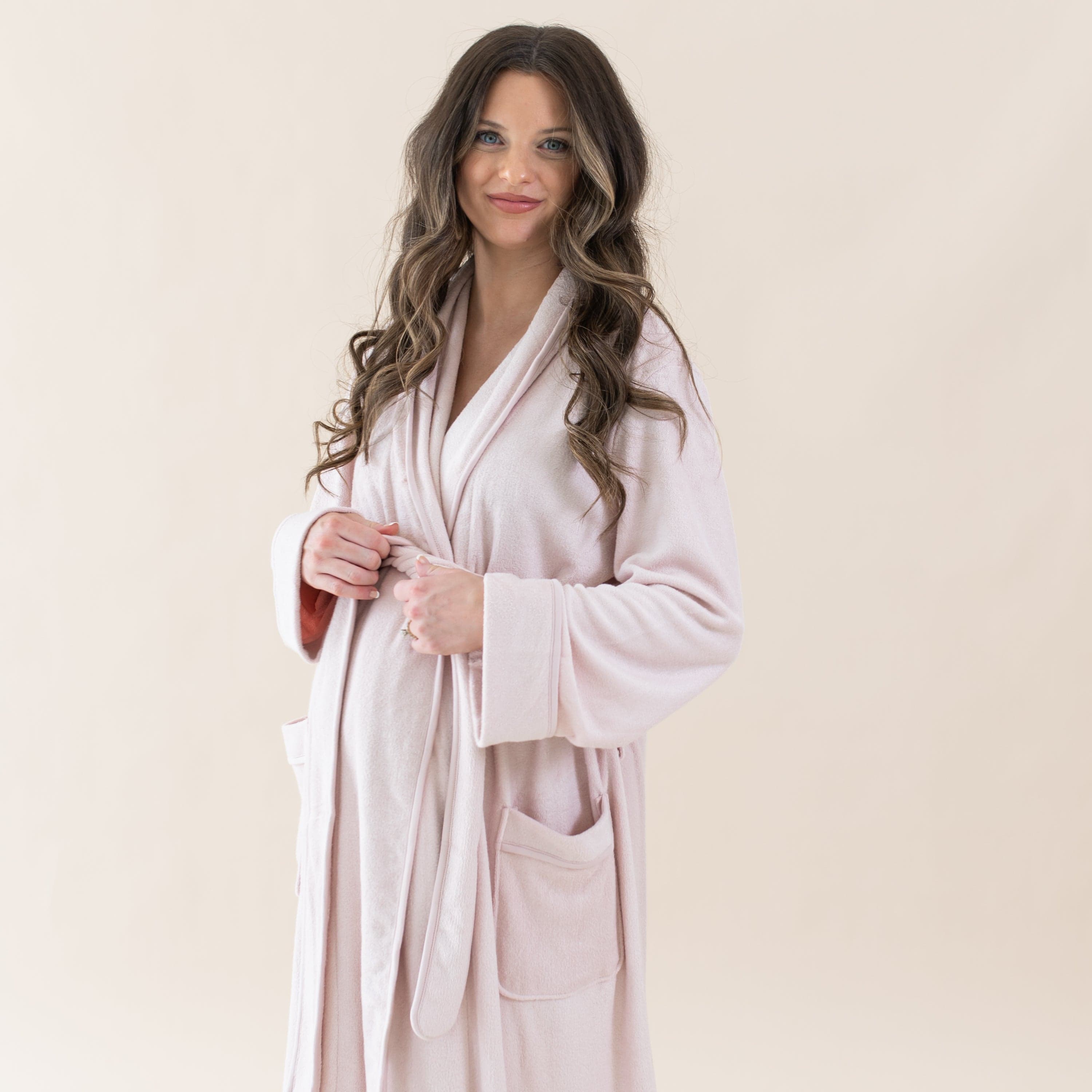 Woman wearing Kyte Baby Adult Robe with self-tie waist in Blush