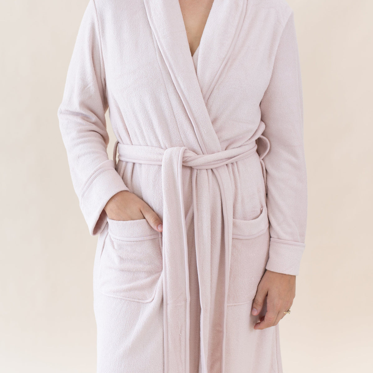 Woman wearing Kyte Baby Adult Robe with front patch pockets in Blush