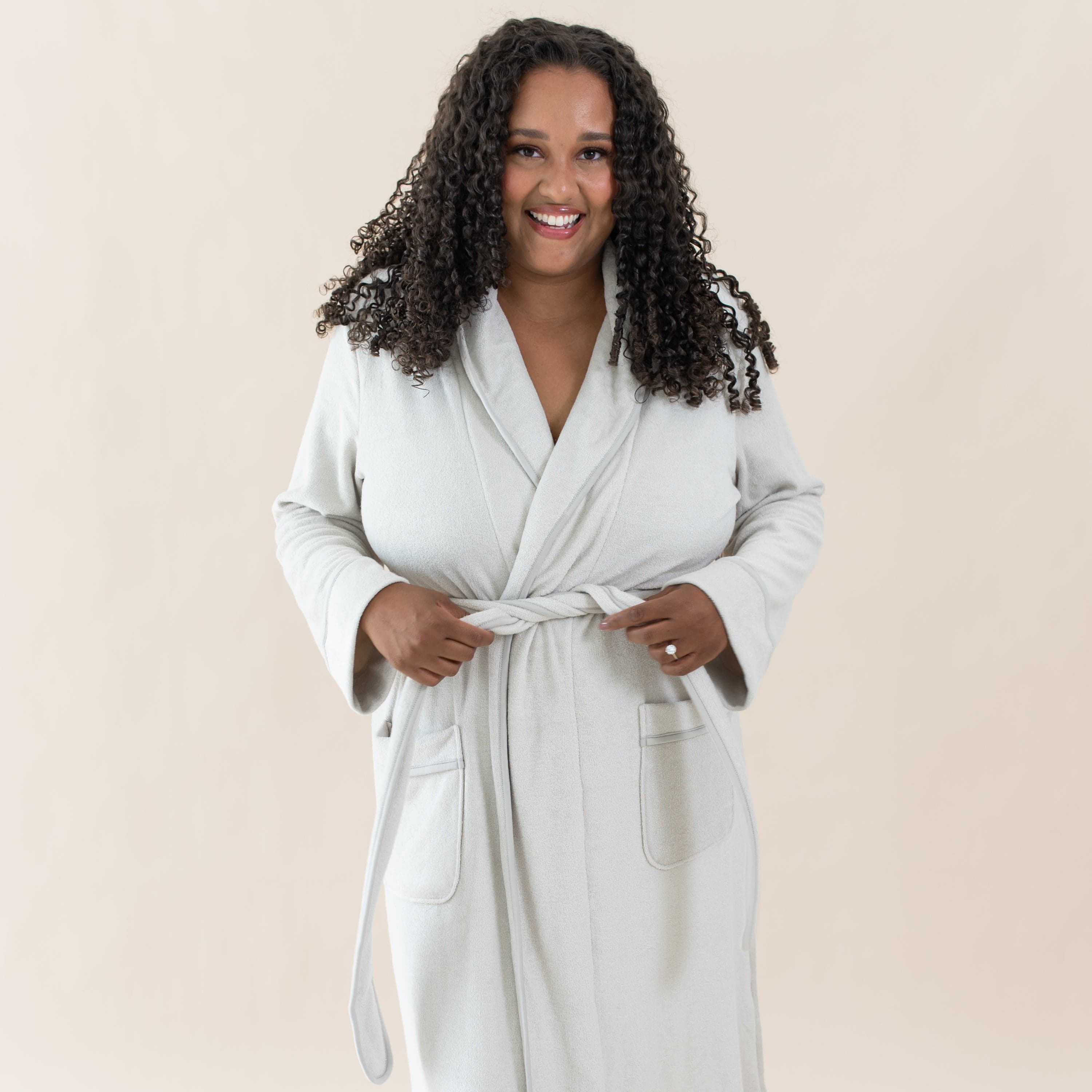Woman wearing Kyte Baby Adult Robe with self-tie waist in Oat