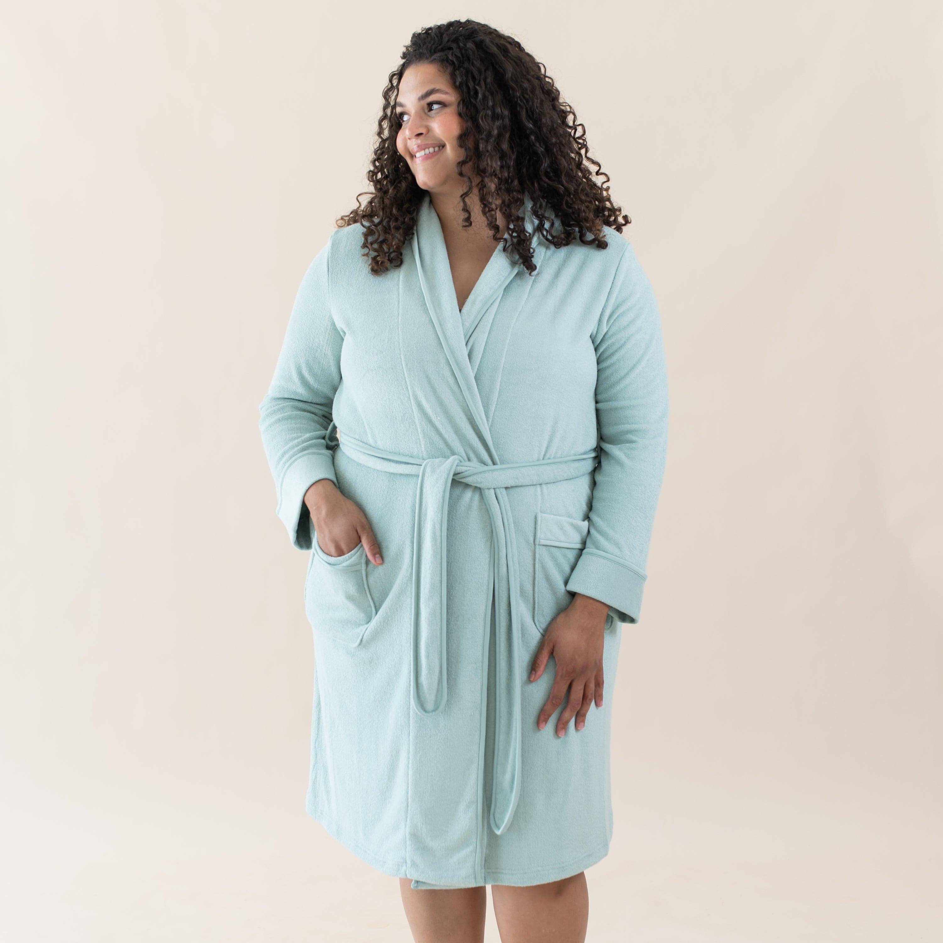 Woman wearing Kyte Baby Adult Robe with front patch pockets in Sage green