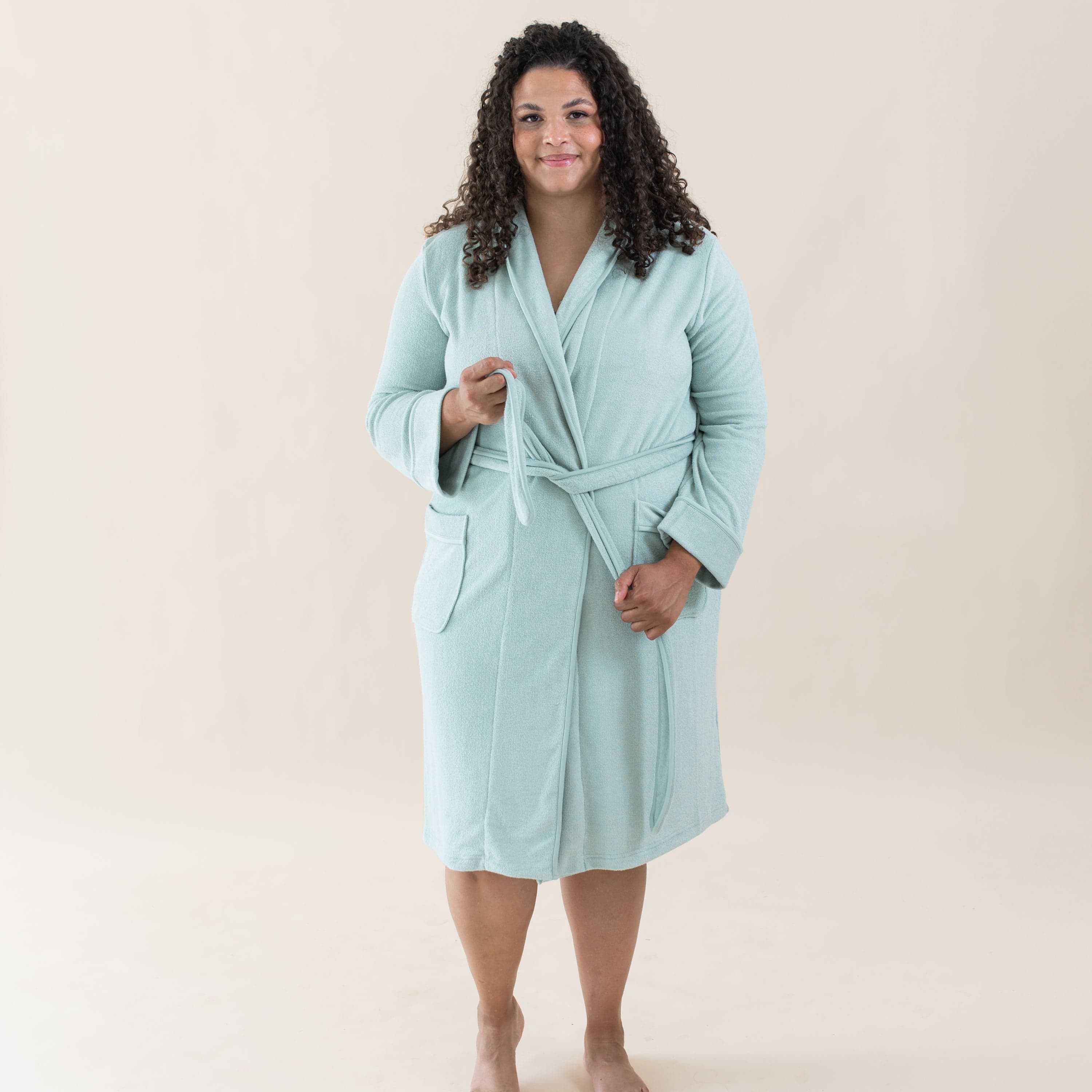 Woman wearing Kyte Baby Adult Robe with self-tie waist in Sage