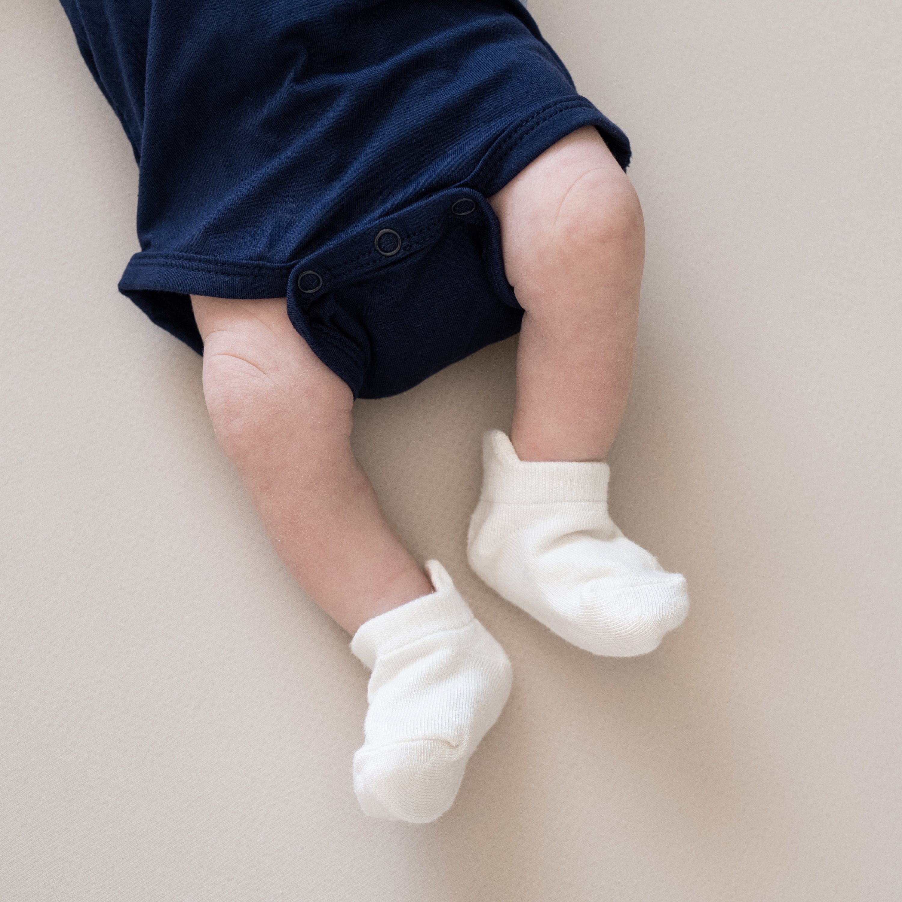 Newborn wearing Kyte Baby Ankle Socks in Cloud white