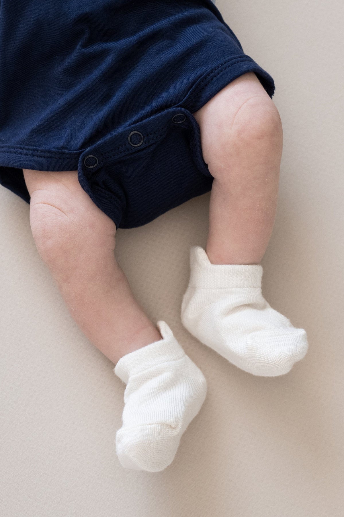 Newborn wearing Kyte Baby Ankle Socks in Cloud white