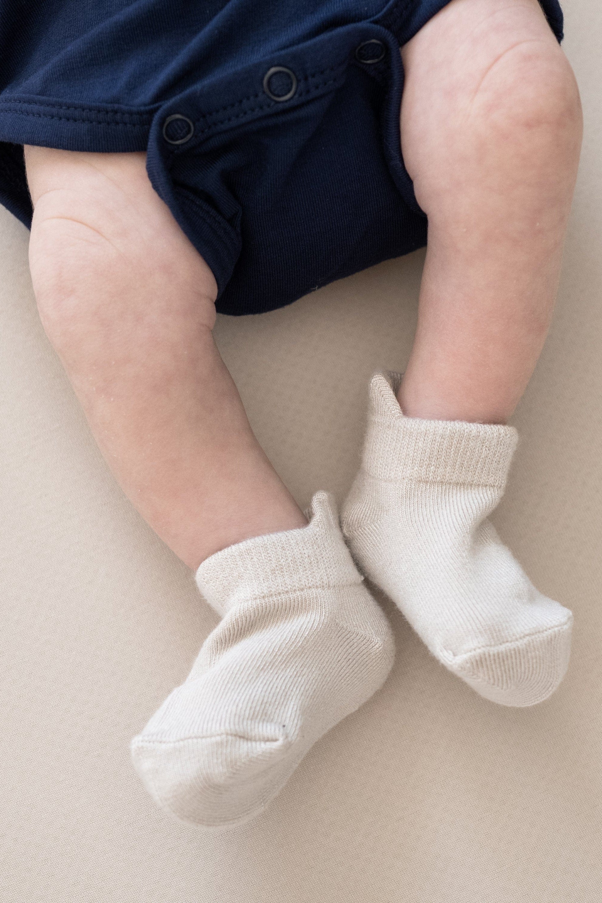 Infant wearing Kyte Baby Ankle Socks in Neutral
