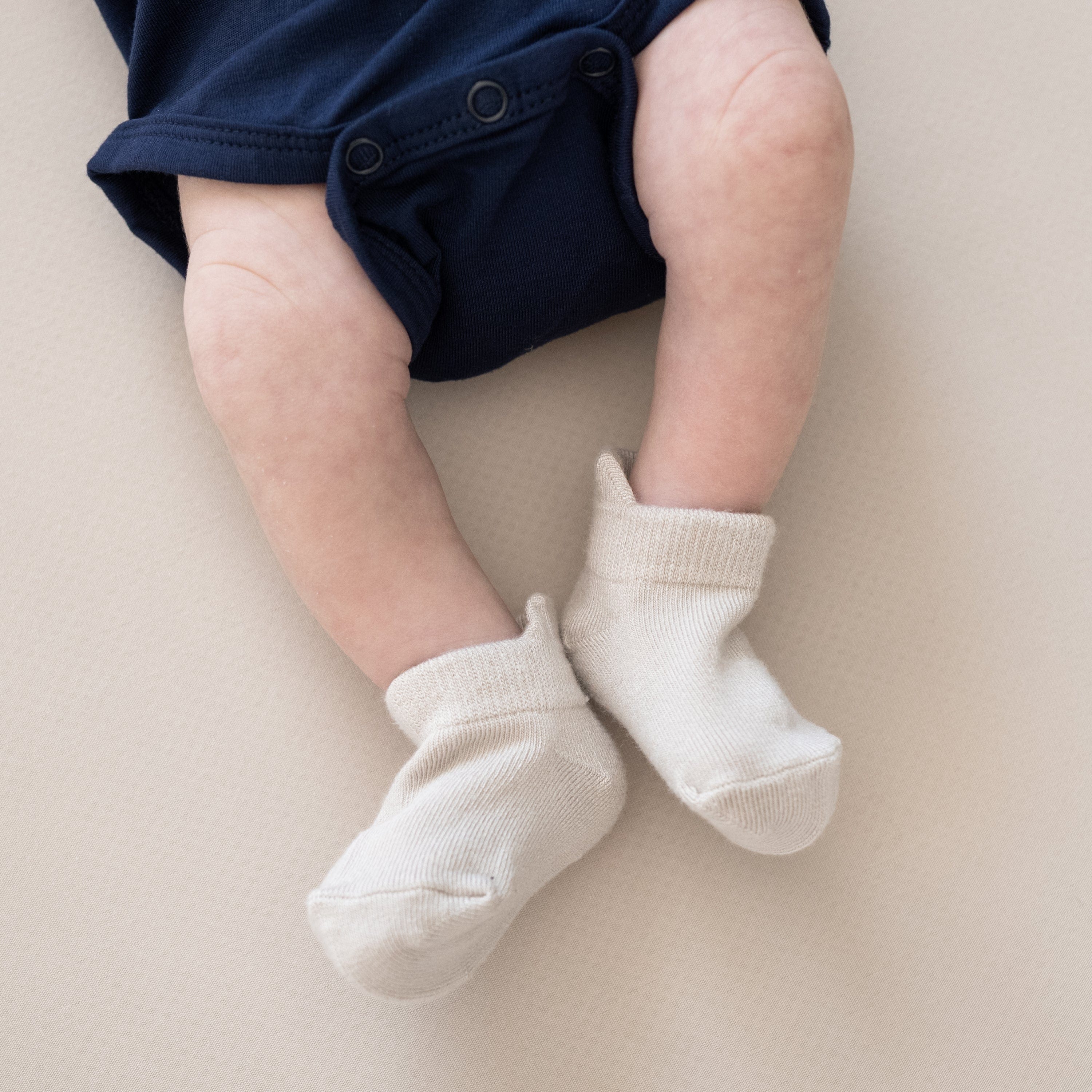 Infant wearing Kyte Baby Ankle Socks in Neutral