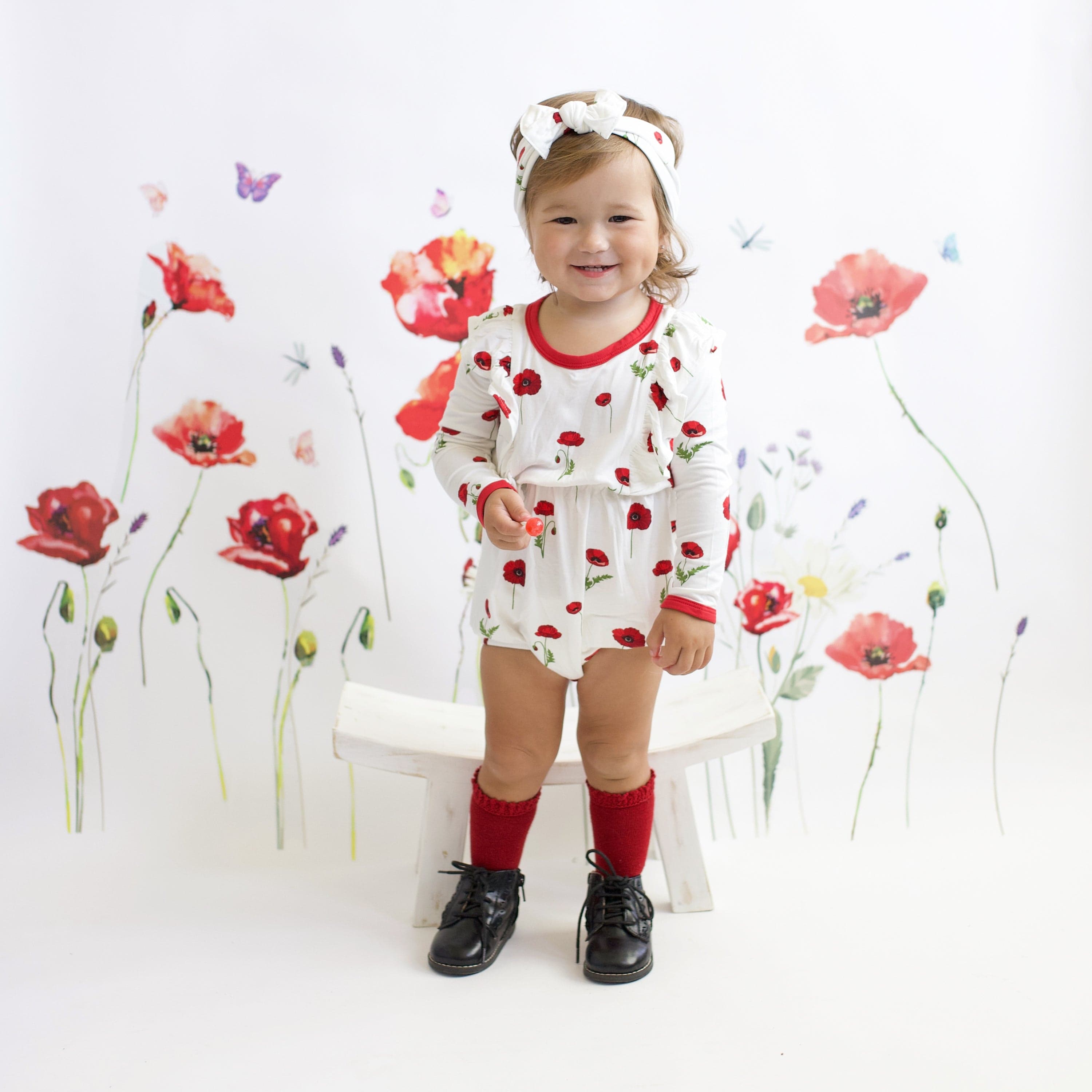 Toddler wearing Kyte Baby bamboo bow headband in Cloud Poppies