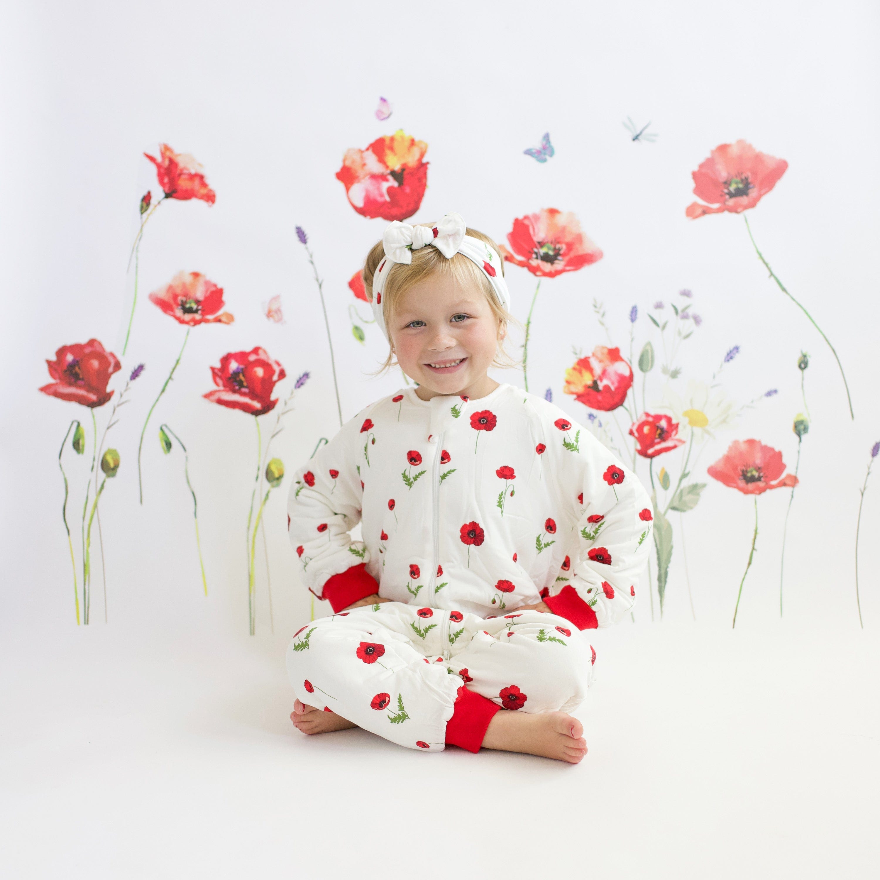 Child wearing Kyte Baby Bow headband in Cloud Poppies