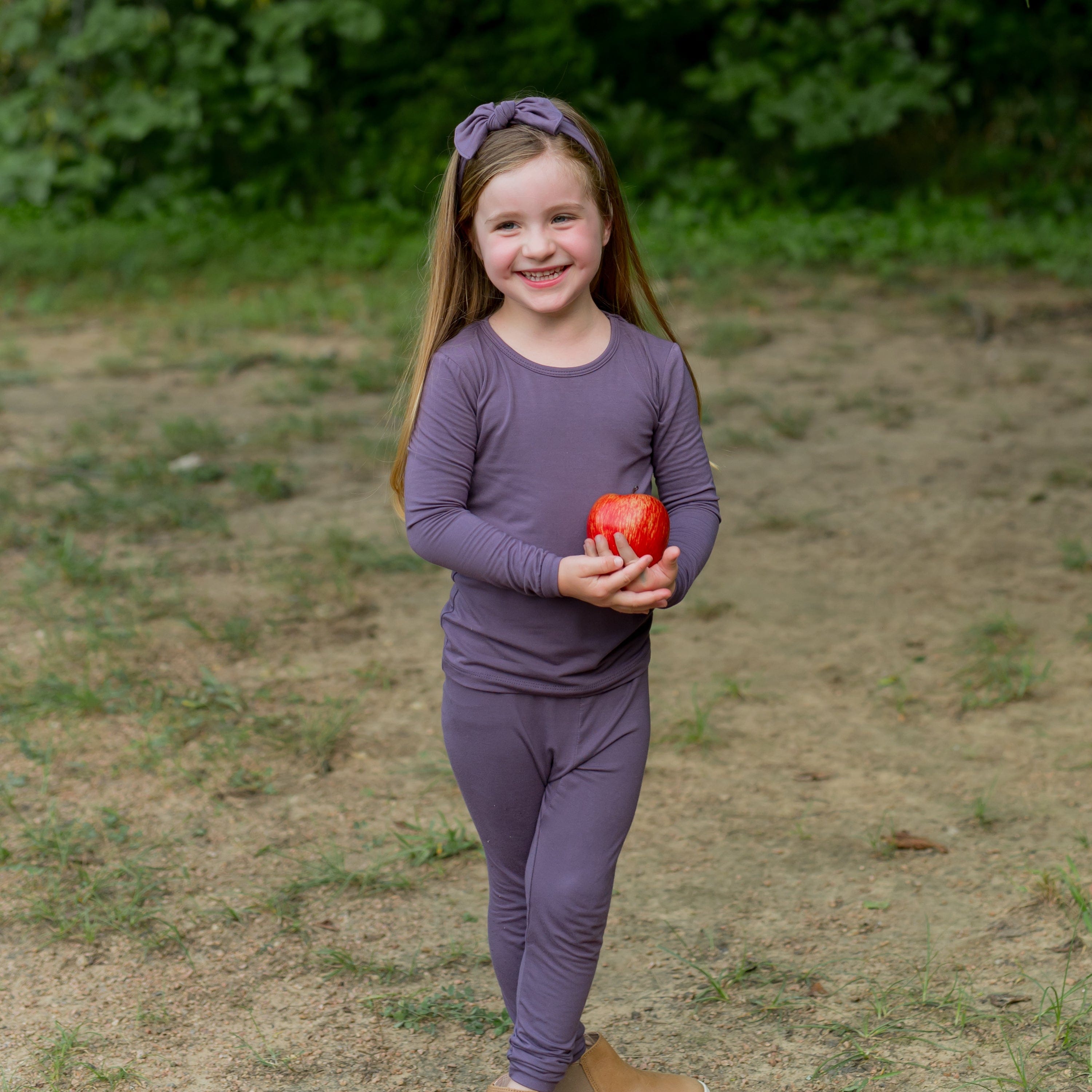 Toddler wearing Long Sleeve pajamas with matching bow in Currant