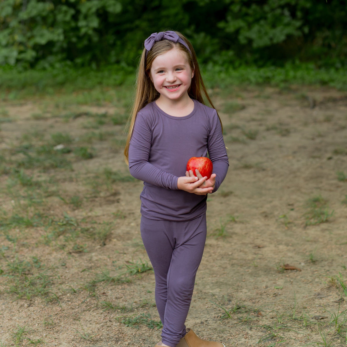 Toddler wearing Long Sleeve pajamas with matching bow in Currant