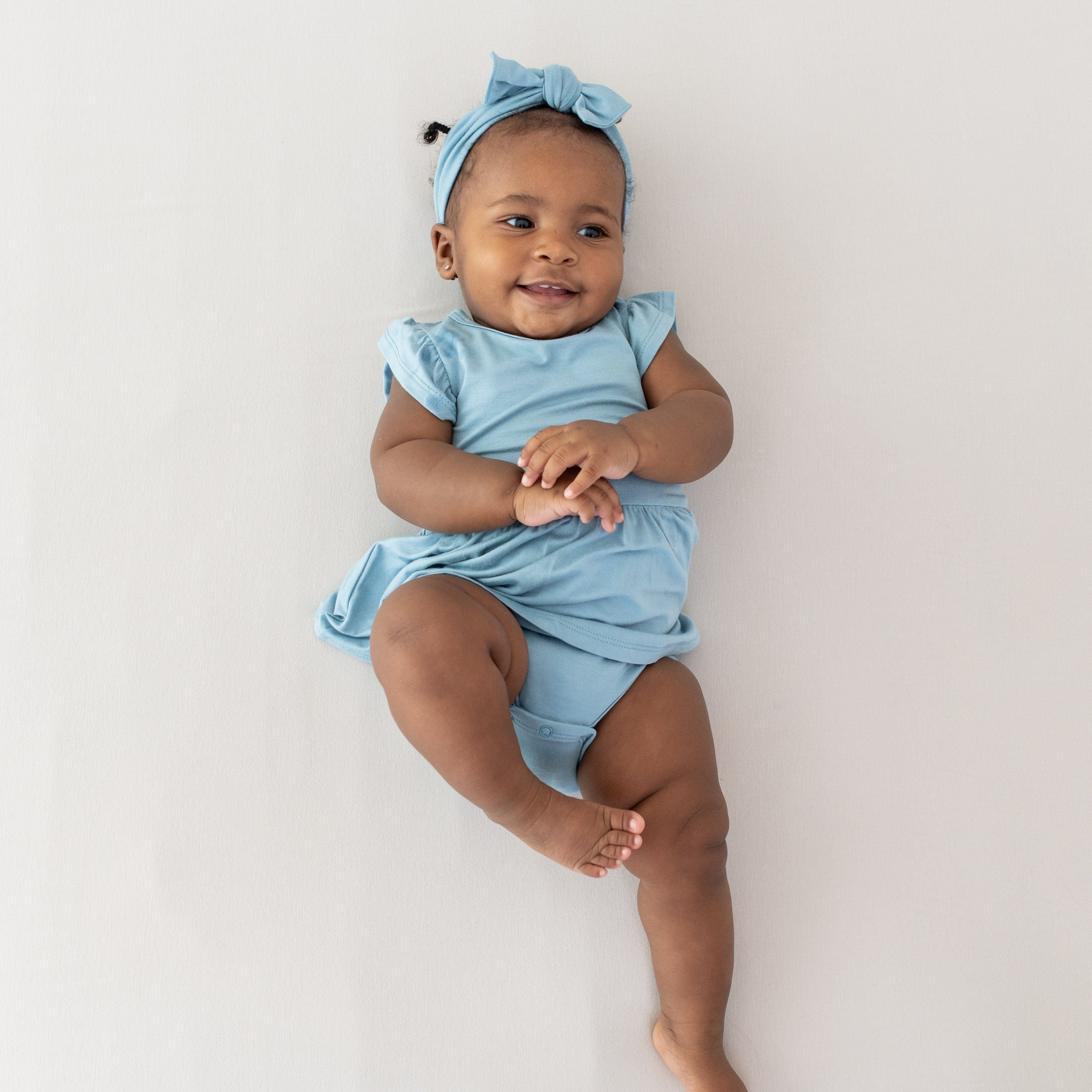Infant wearing Kyte Baby Bow in Dusty Blue