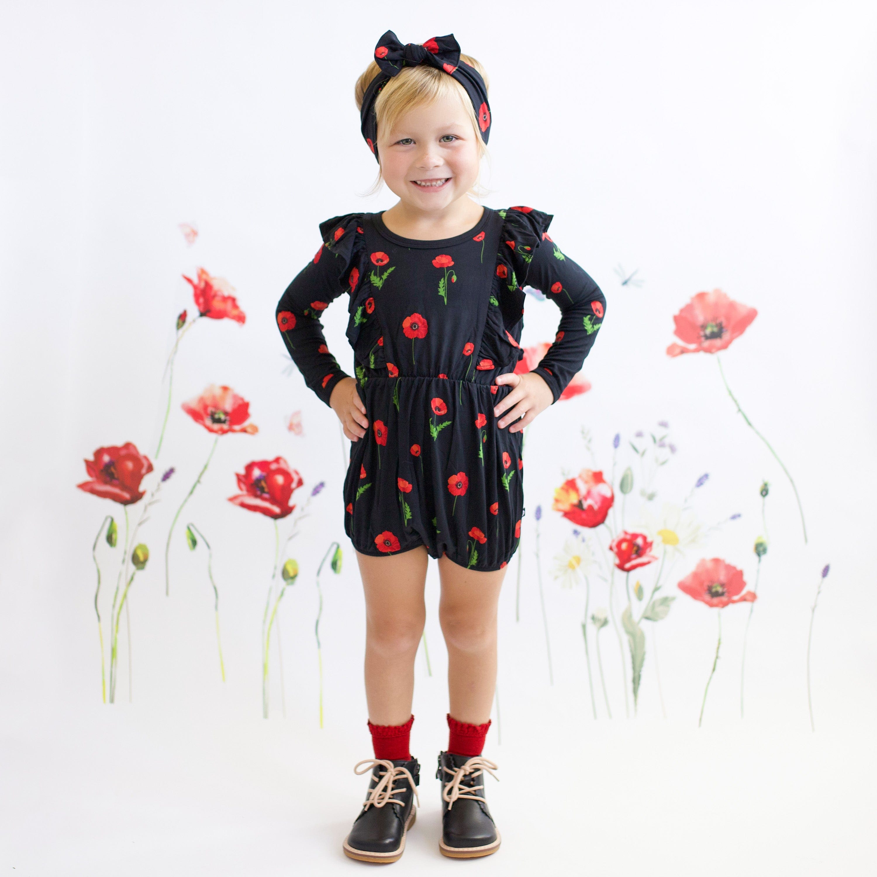 Child wearing Kyte Baby Bow in Midnight Poppies