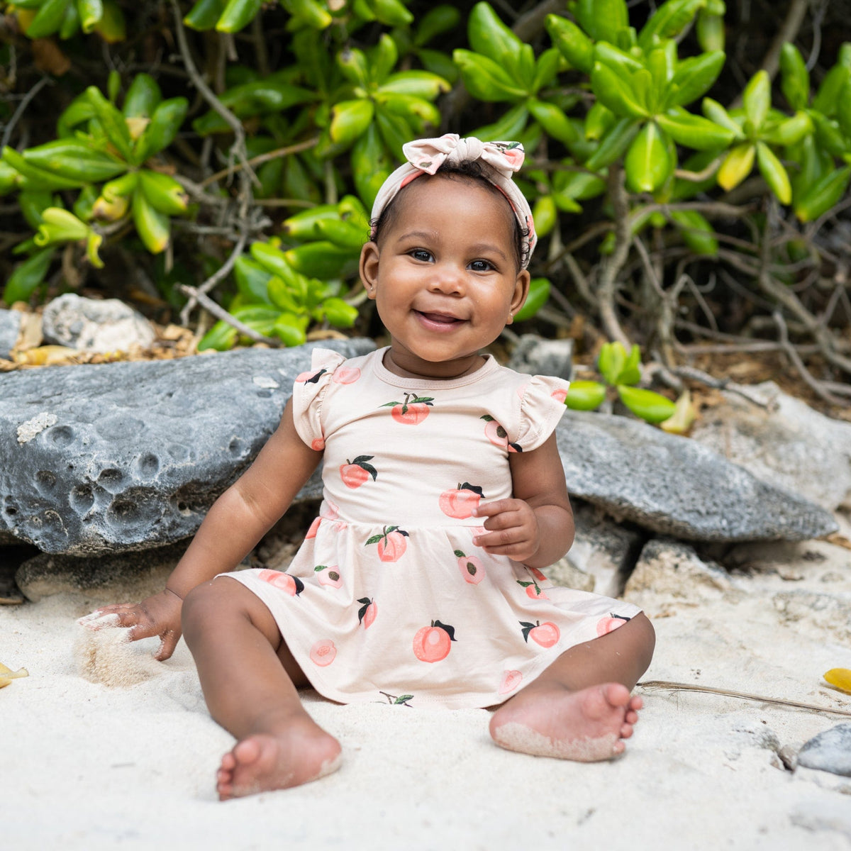Infant wearing Kyte Baby Bow in Peach