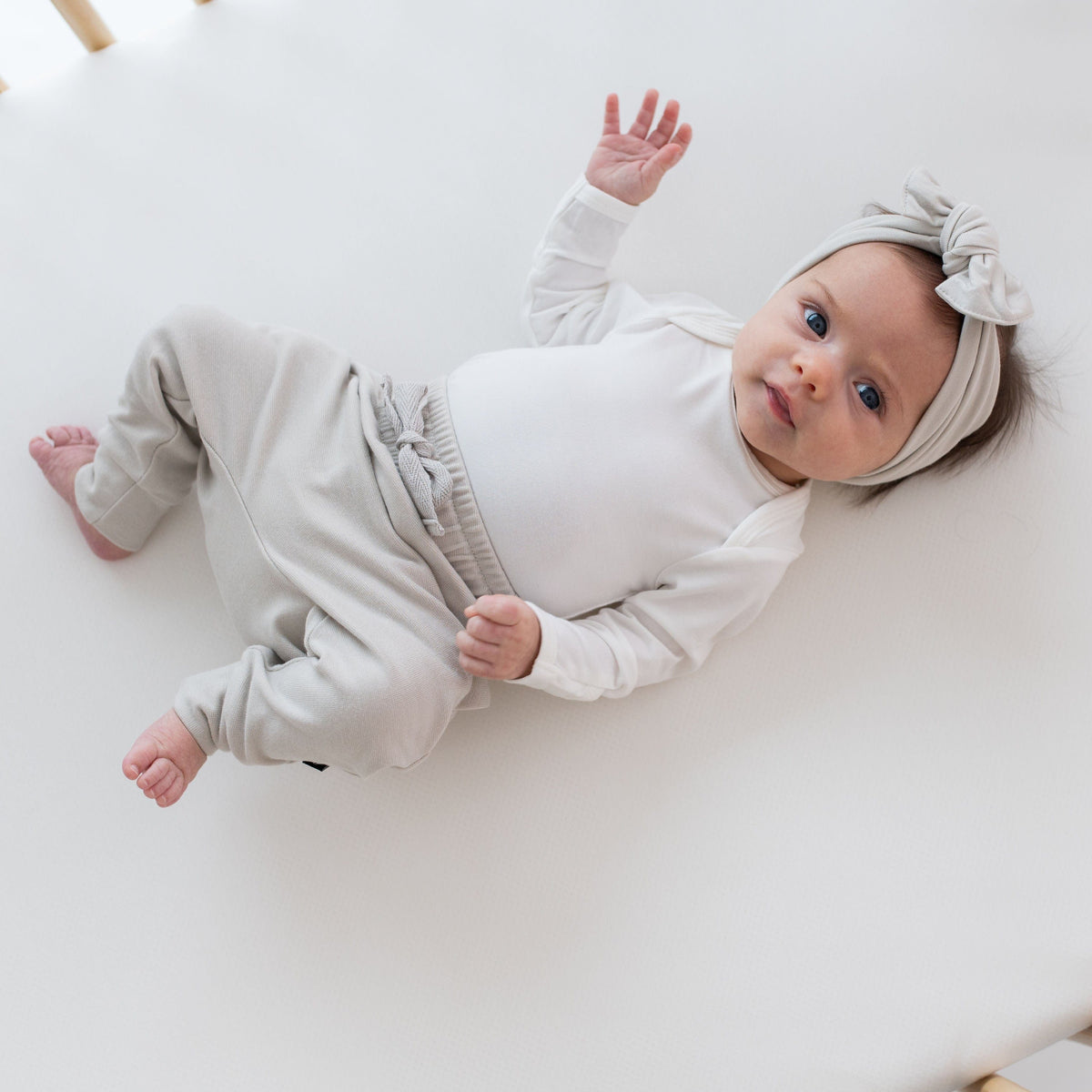 Infant wearing Kyte Baby Bamboo Jersey Harem Pants in Oat