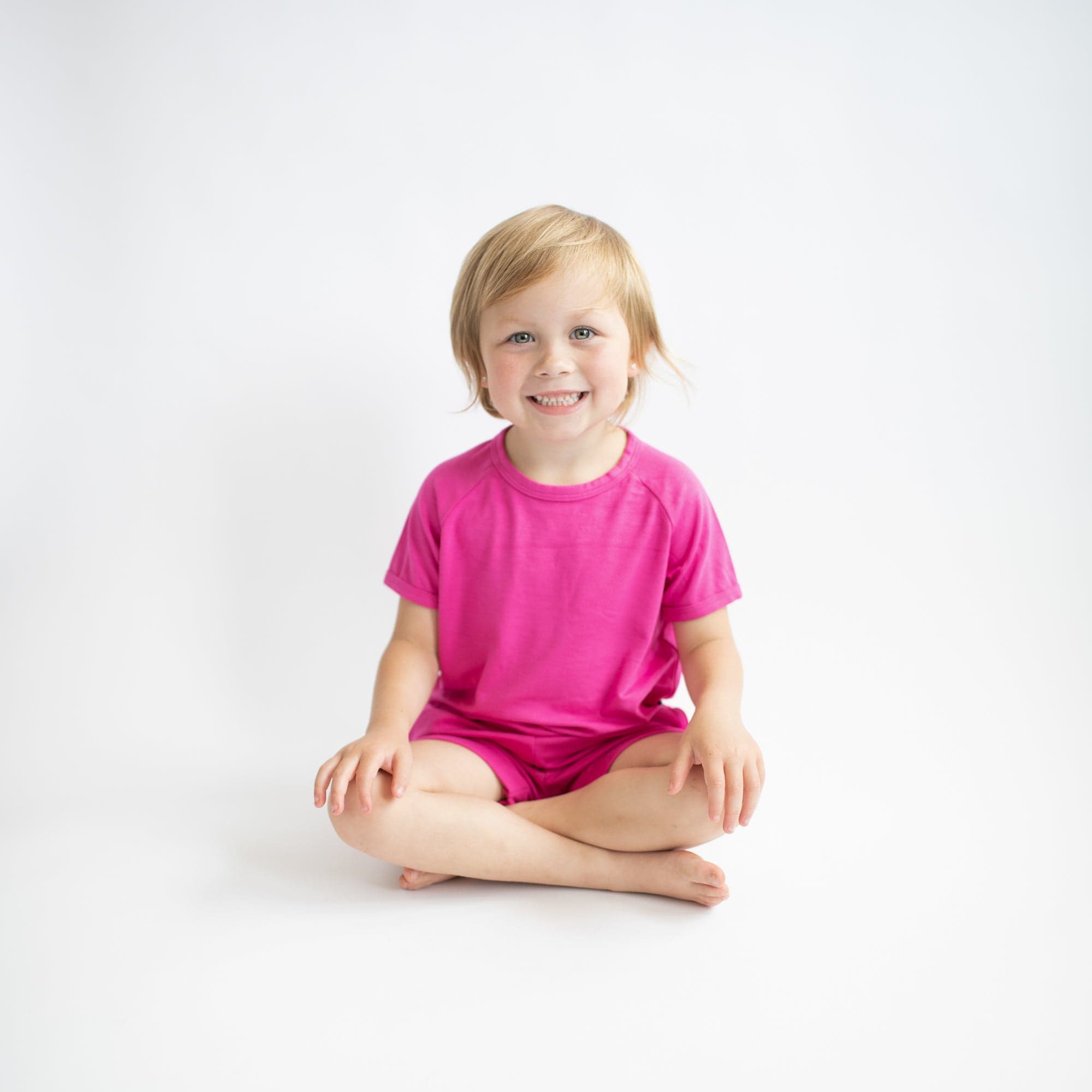 Toddler wearing Kyte Baby Bamboo Jersey Short Sleeve Jogger Set in Raspberry