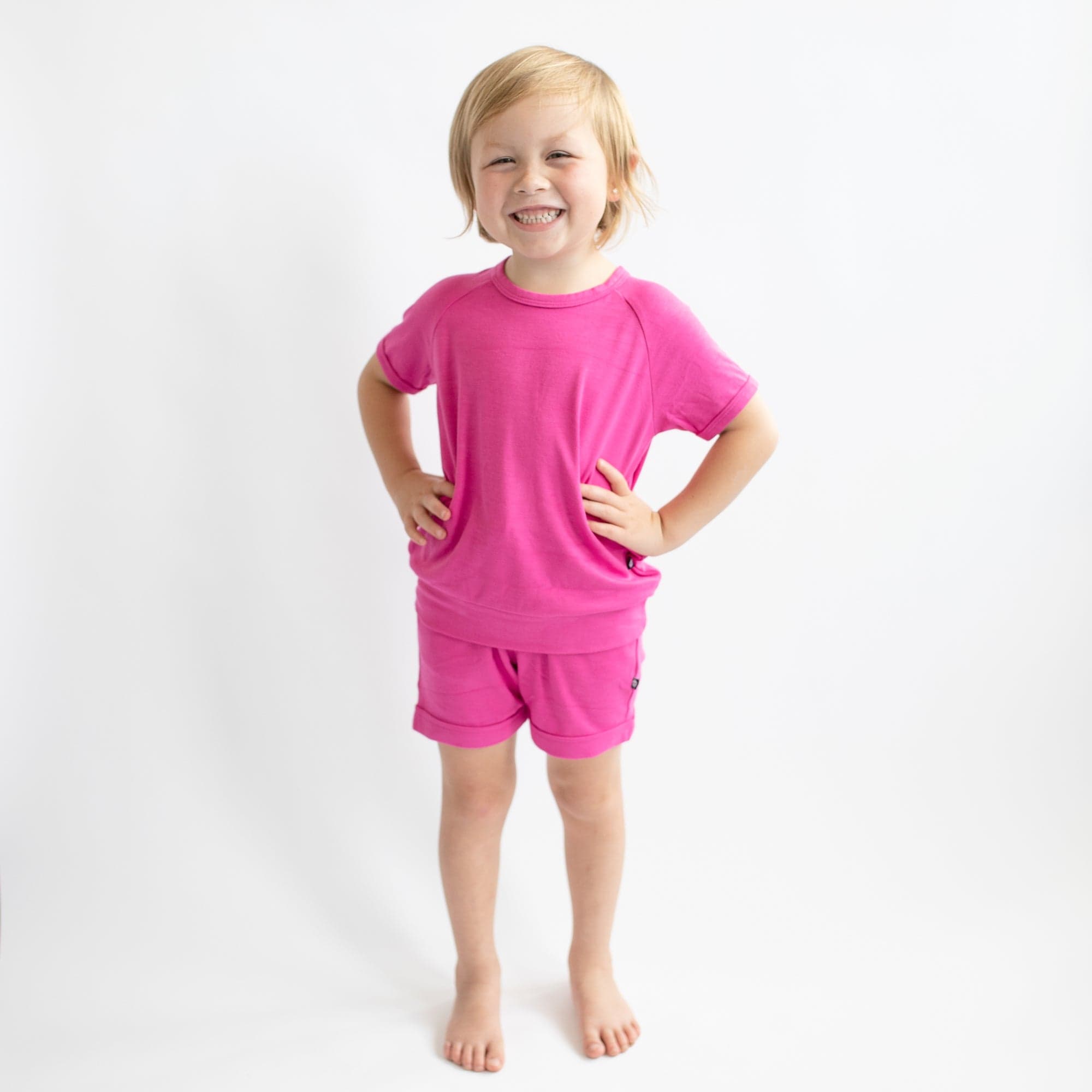 Girl wearing Kyte Baby Bamboo Jersey Short Sleeve Jogger Set in Raspberry