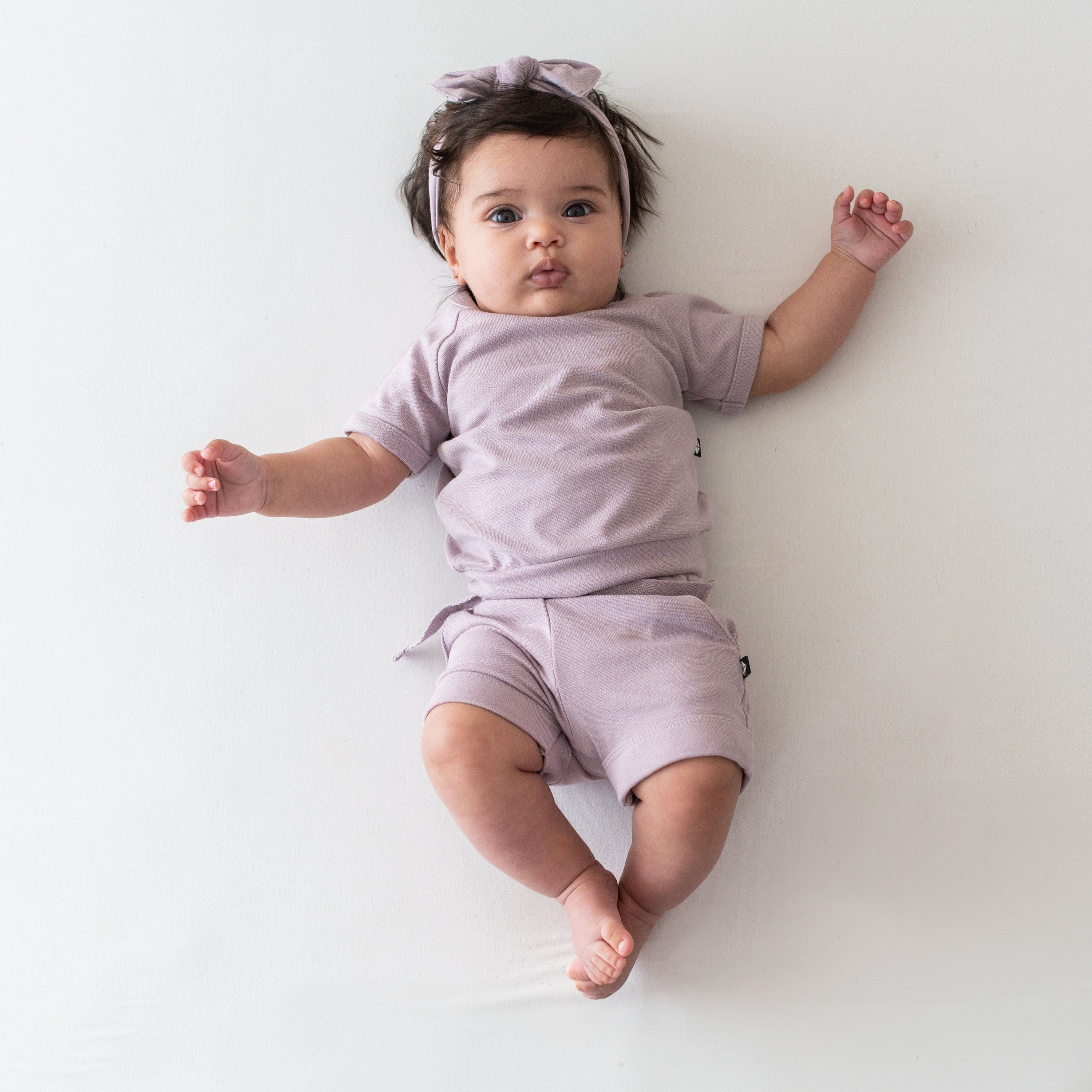 Infant wearing Kyte Baby Bamboo Jersey Short Sleeve Jogger Set in Wisteria