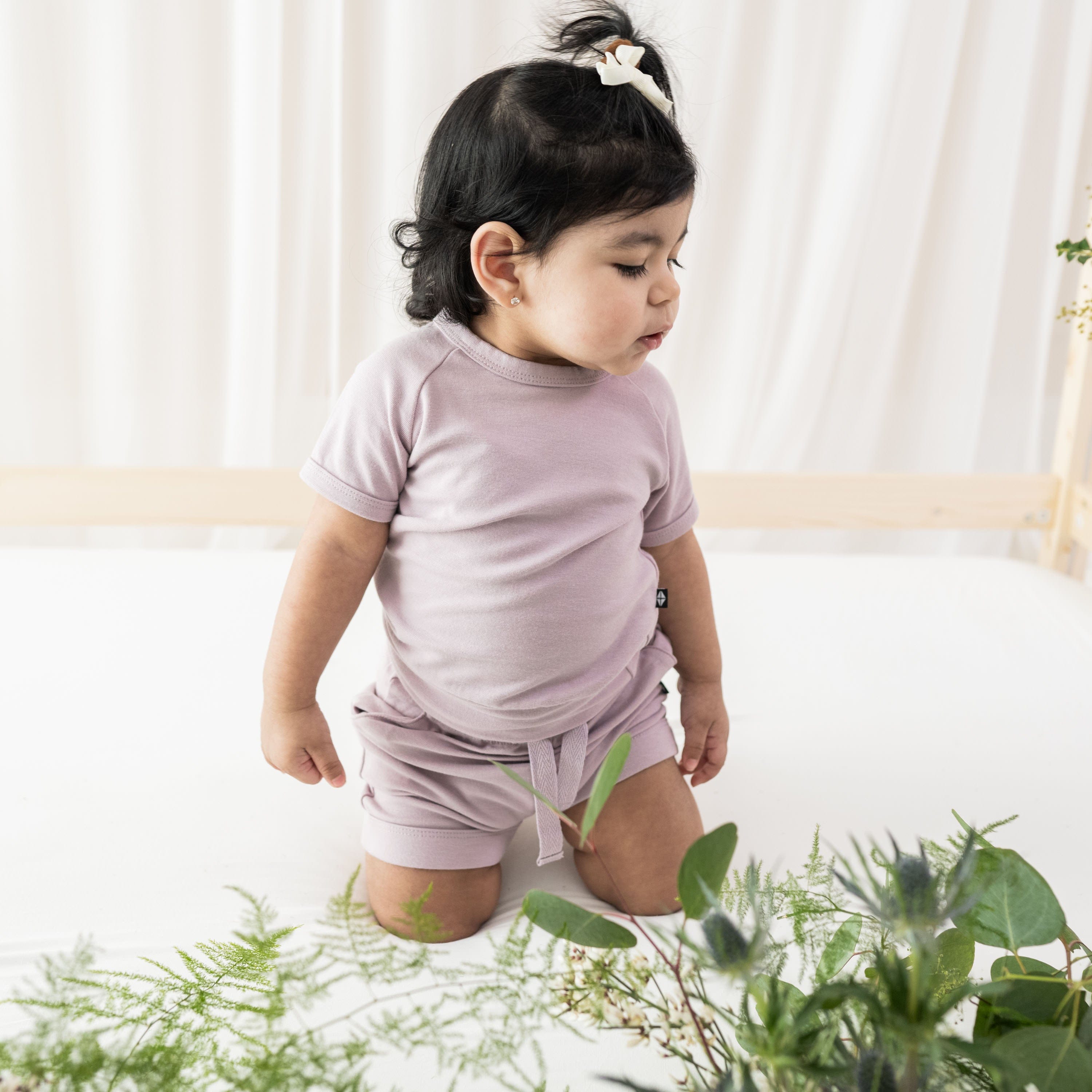 Girl wearing Kyte Baby Bamboo Jersey Short cuffed Sleeve Jogger Set in Wisteria