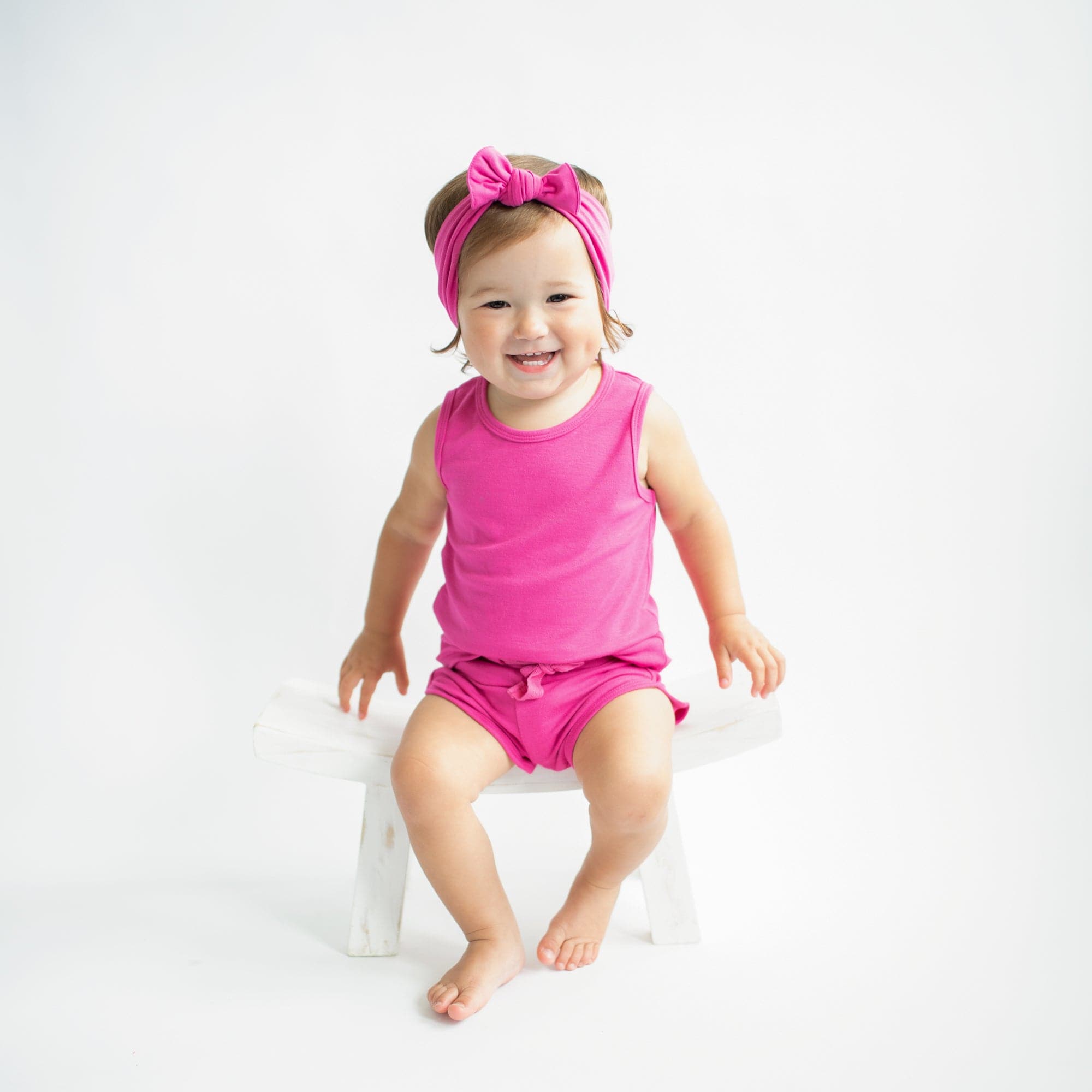 Toddler wearing Kyte Baby Bamboo Jersey Tank Jogger Set with shorts in Raspberry pink