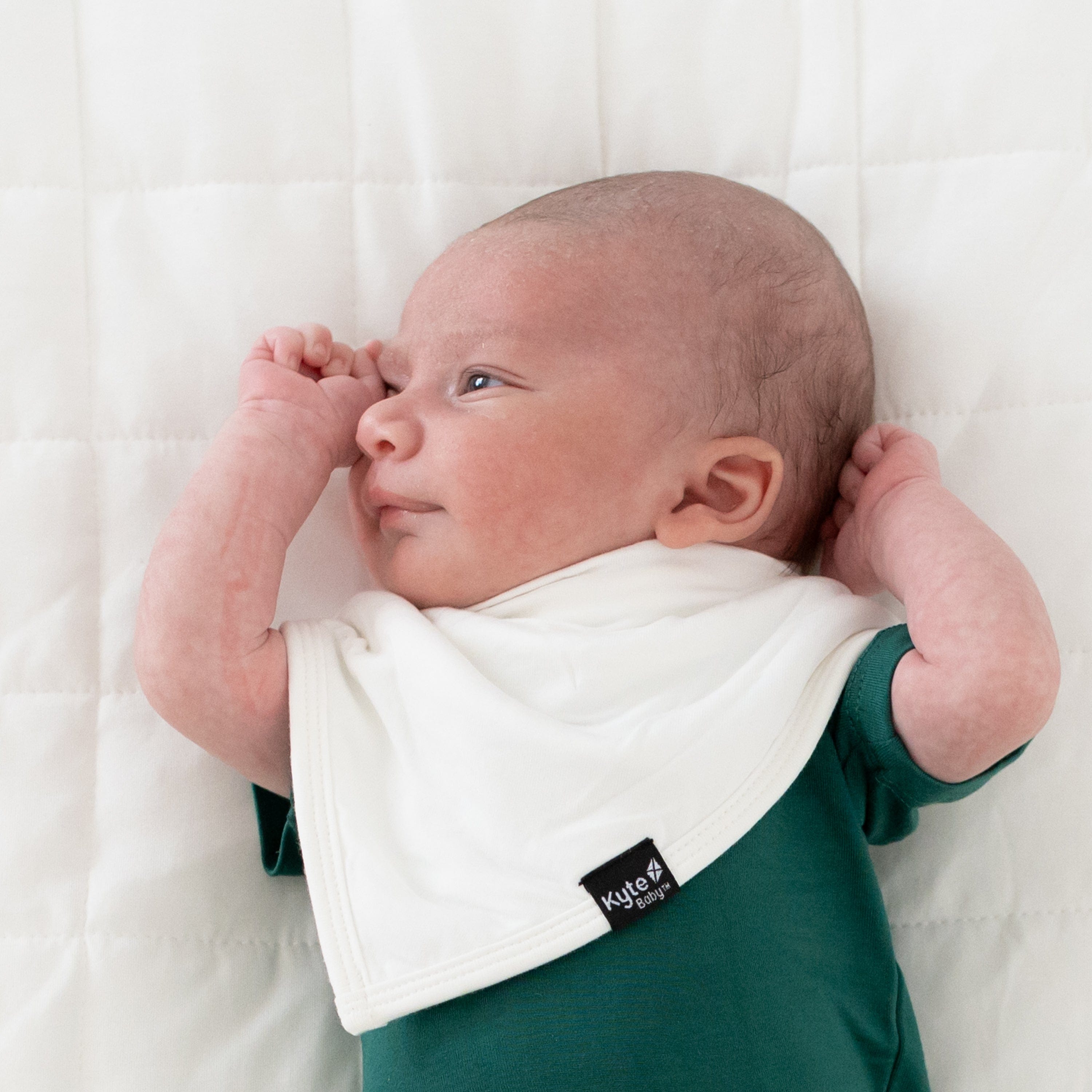 Newborn wearing bamboo Kyte Baby Bib in Cloud