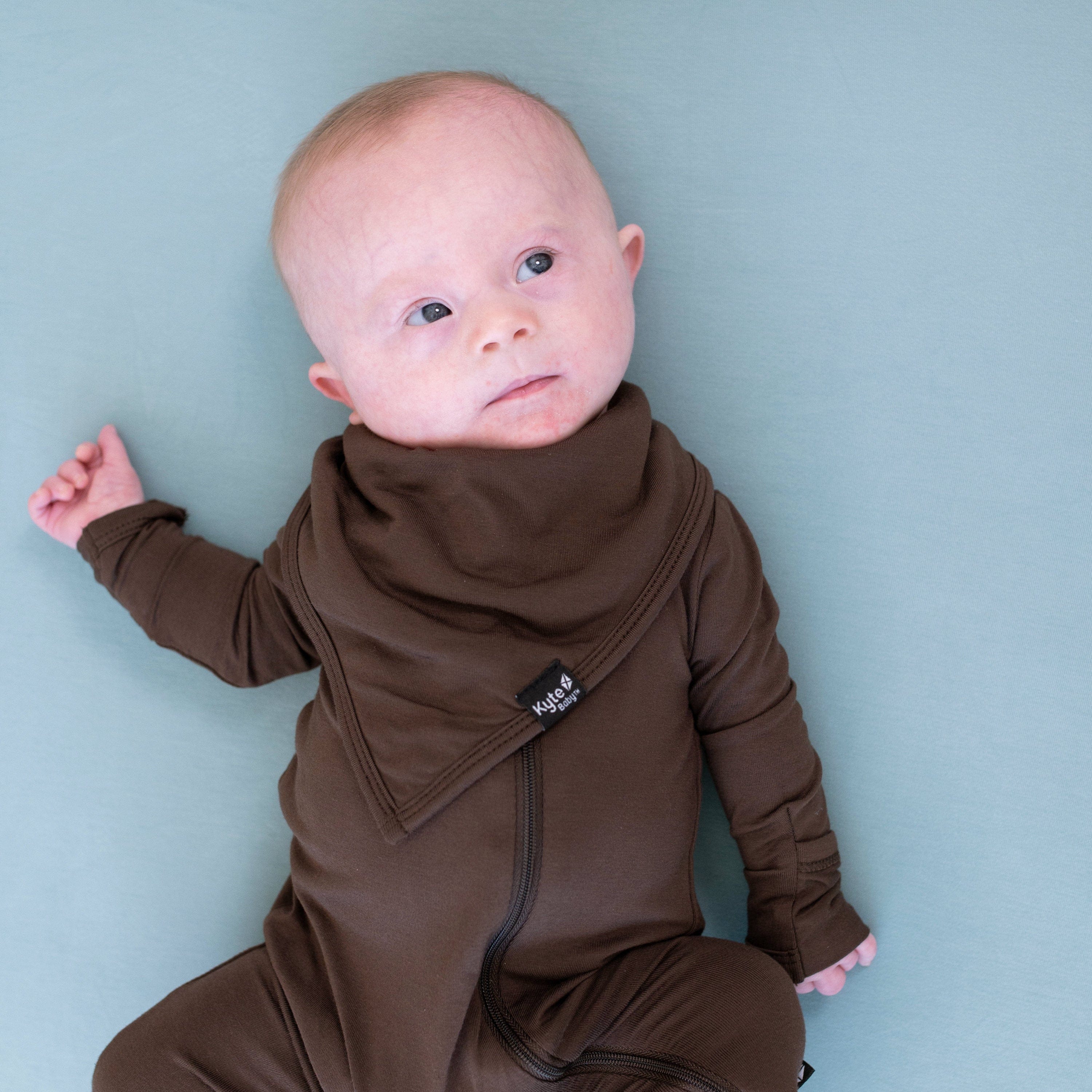 Infant wearing an Bib in Espresso with a matching zippered romper
