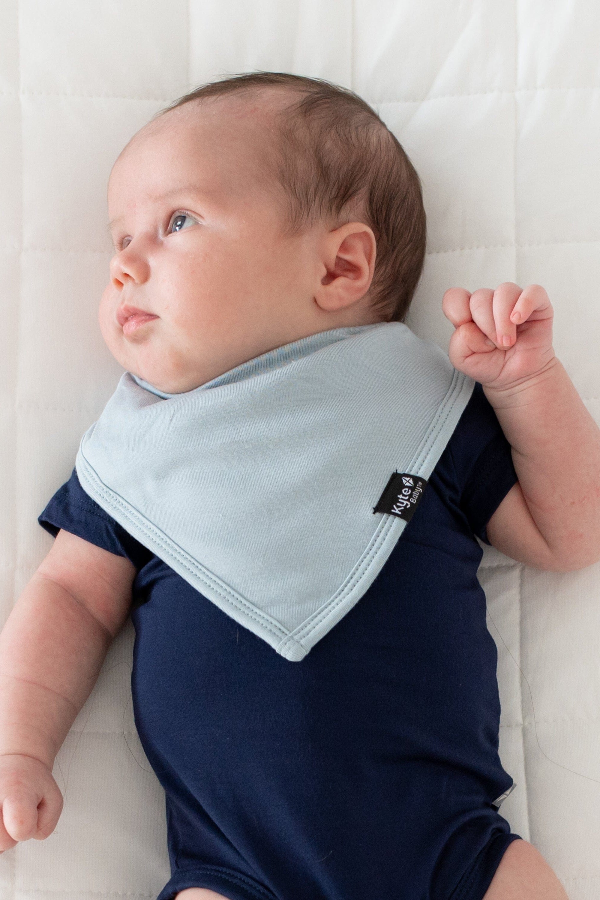 Infant wearing Kyte Baby Bib in Fog