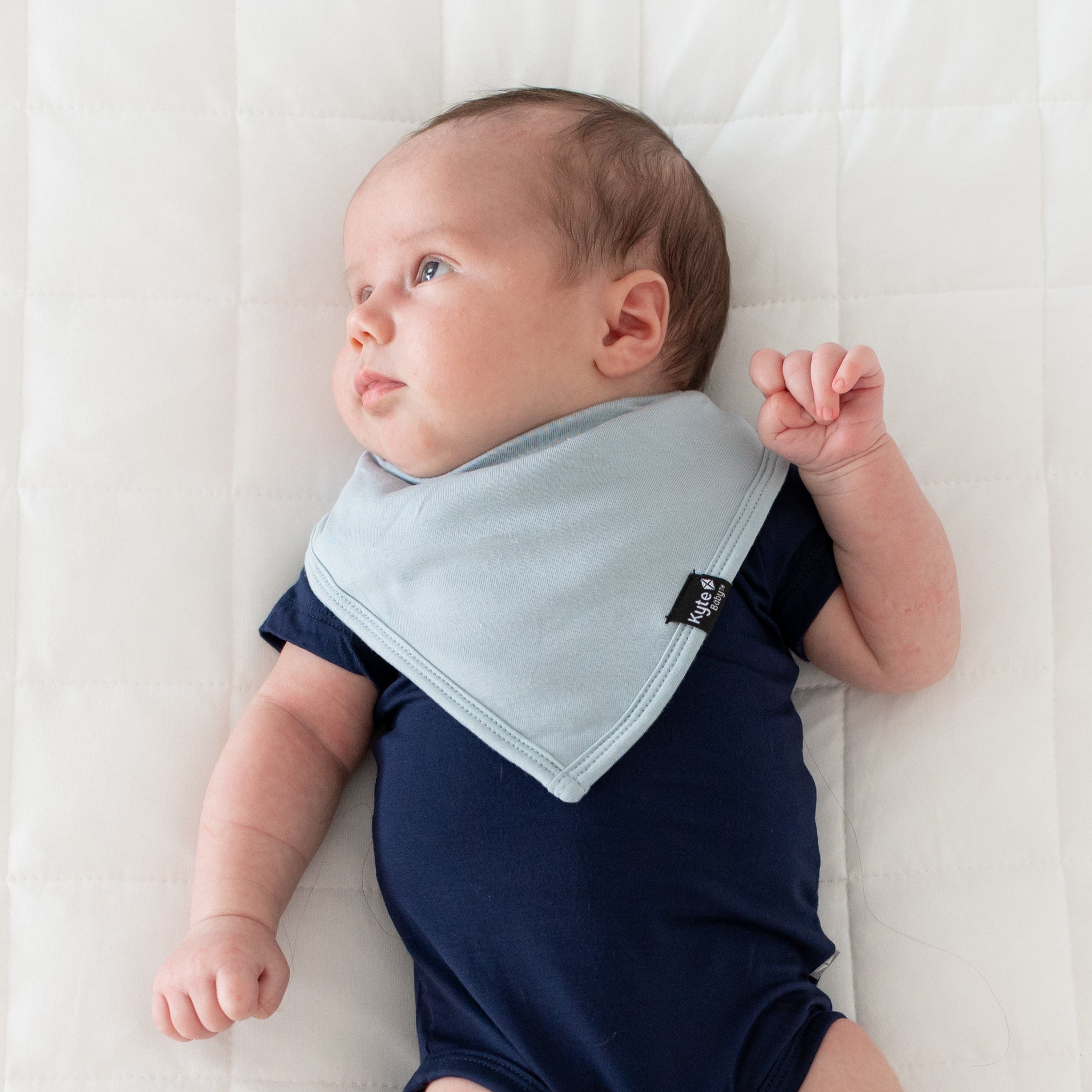 Infant wearing Kyte Baby Bib in Fog