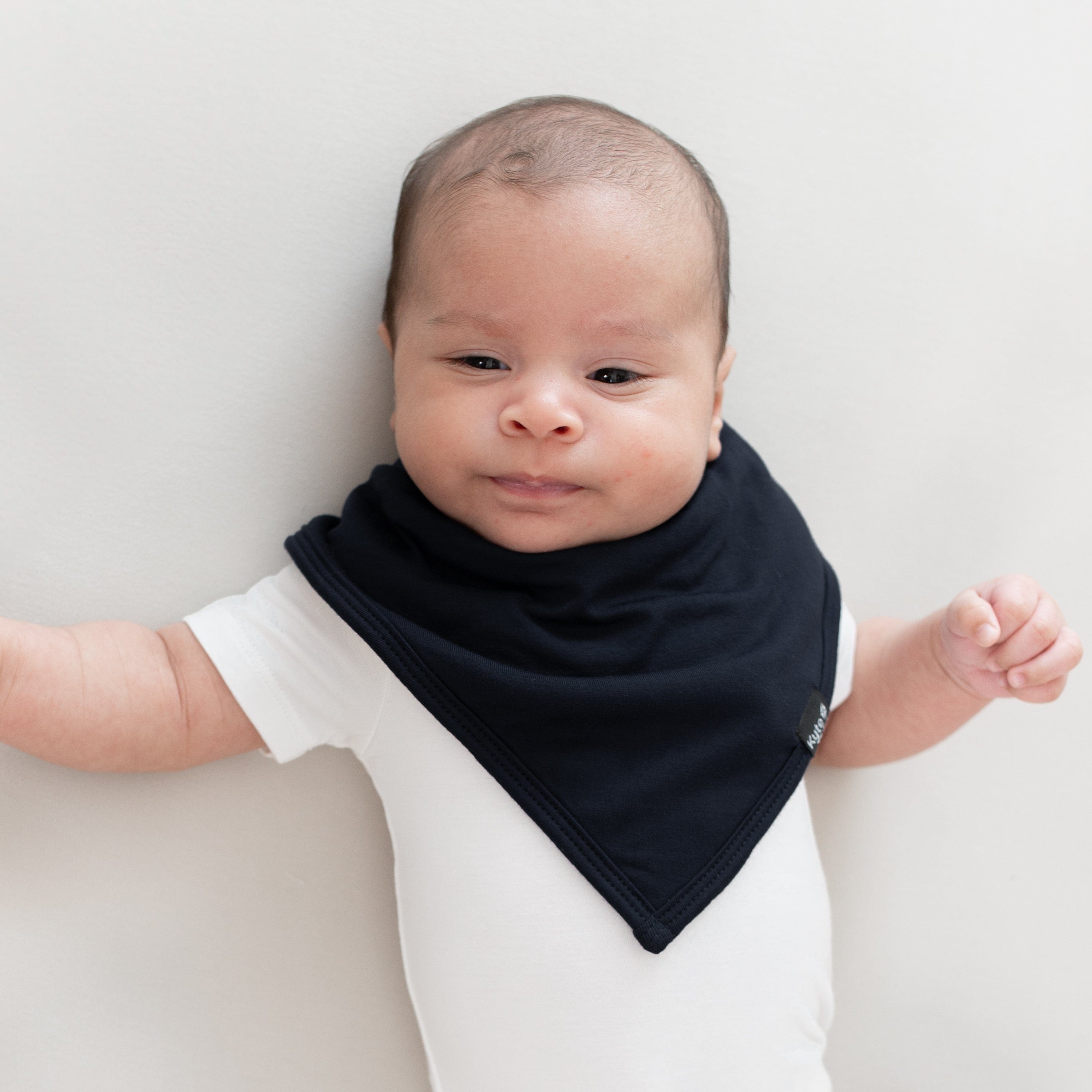 Baby wearing the Kyte Baby Bib in Midnight