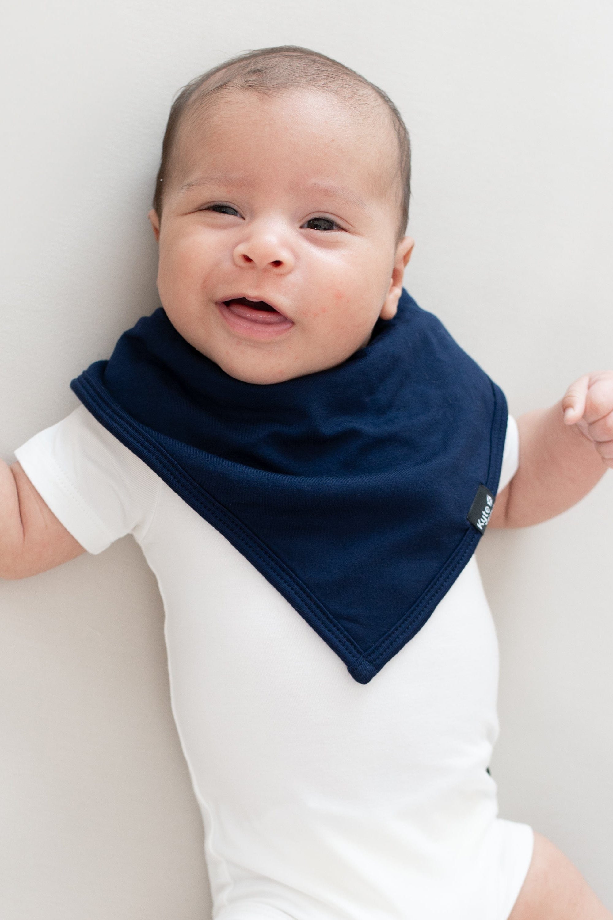 Smiling baby modeling a Bib in Navy and Short Sleeve Bodysuit in Cloud