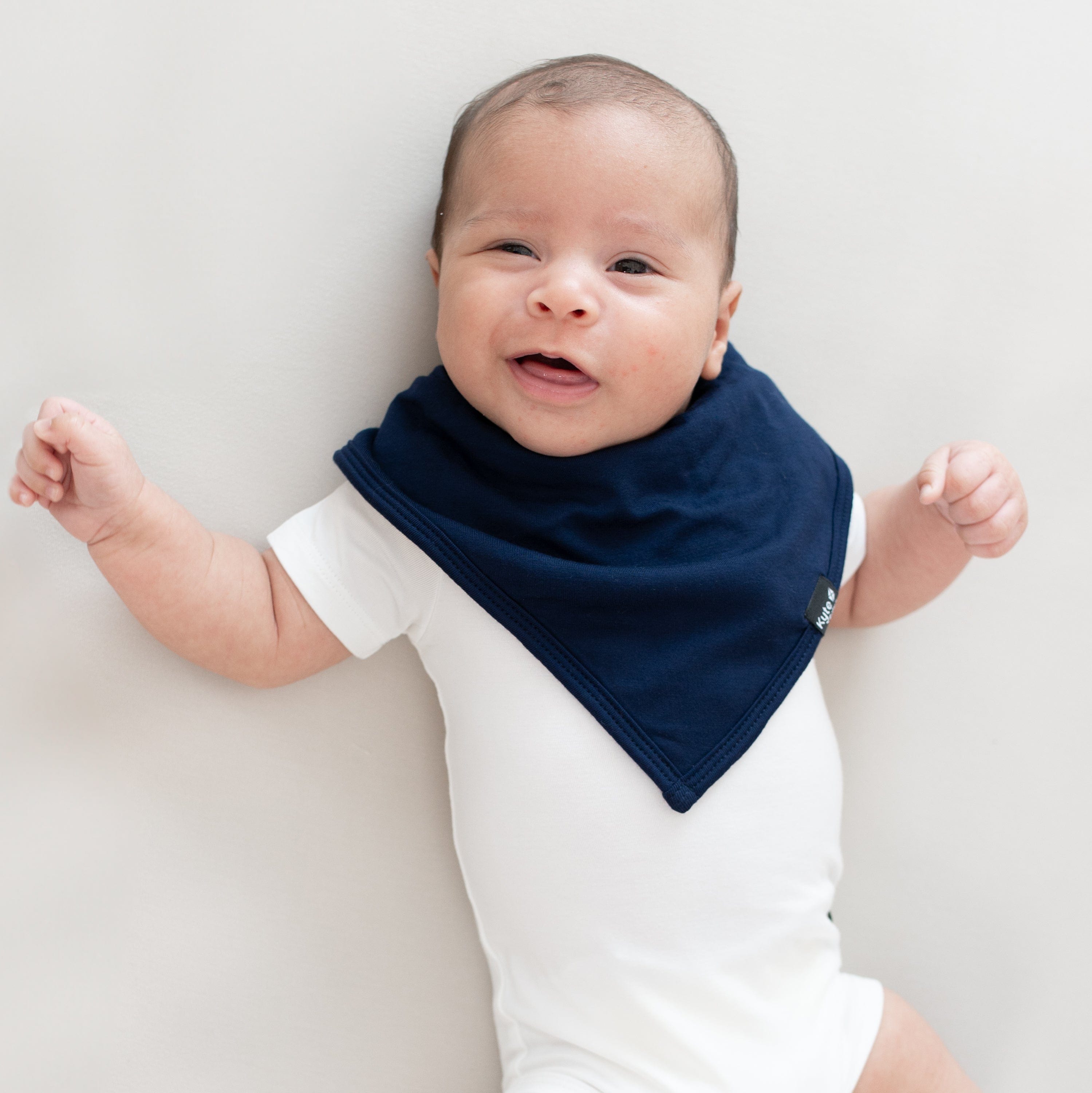Smiling baby modeling a Bib in Navy and Short Sleeve Bodysuit in Cloud