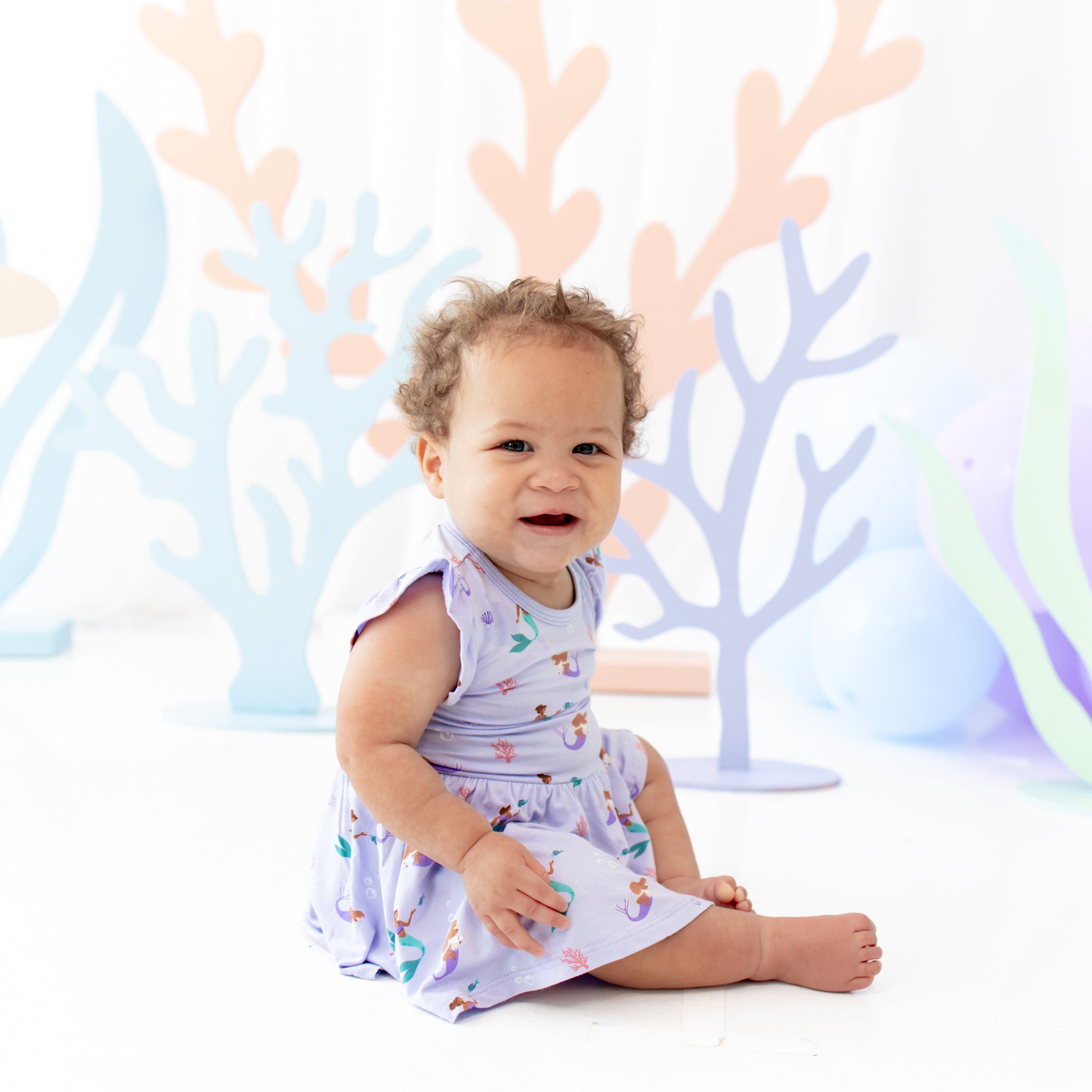 Infant wearing Kyte Baby Twirl Bodysuit Dress in Mermaid