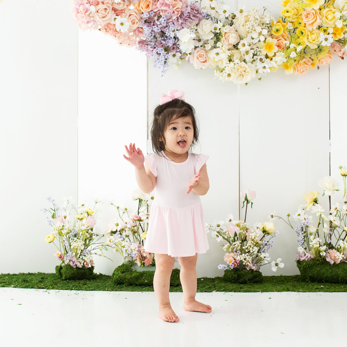 Toddler wearing bamboo Kyte Baby Twirl Bodysuit in Sakura