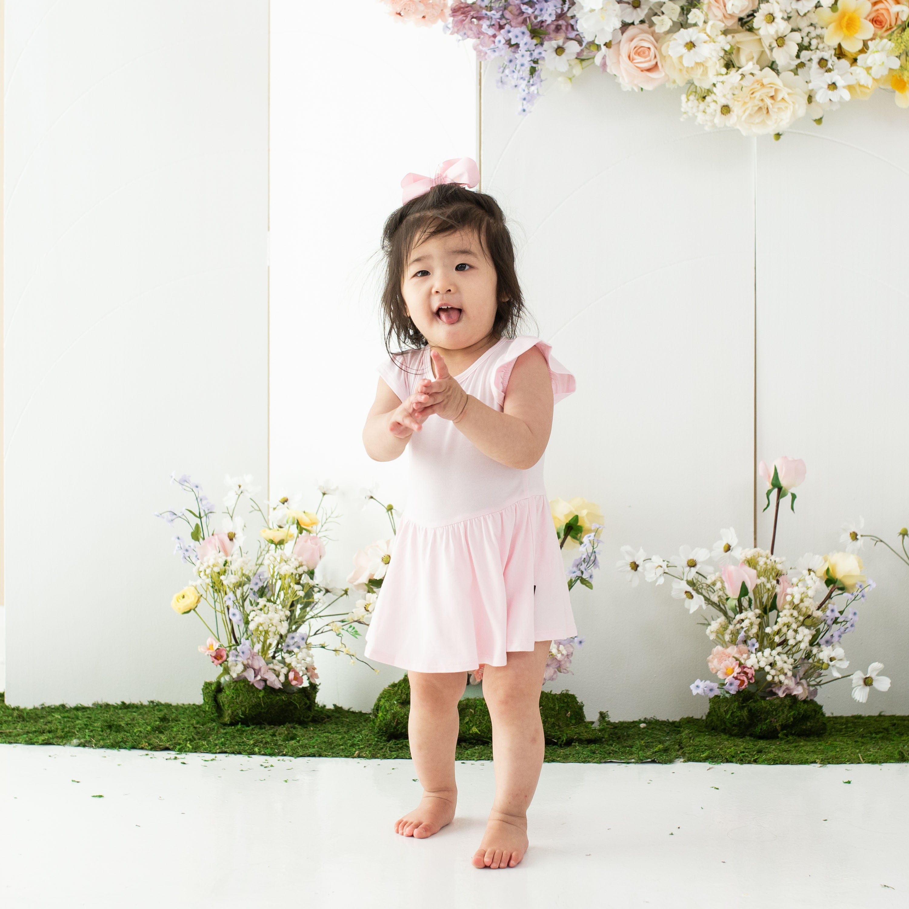 Toddler wearing Kyte Baby Twirl Bodysuit Dress in Sakura pink