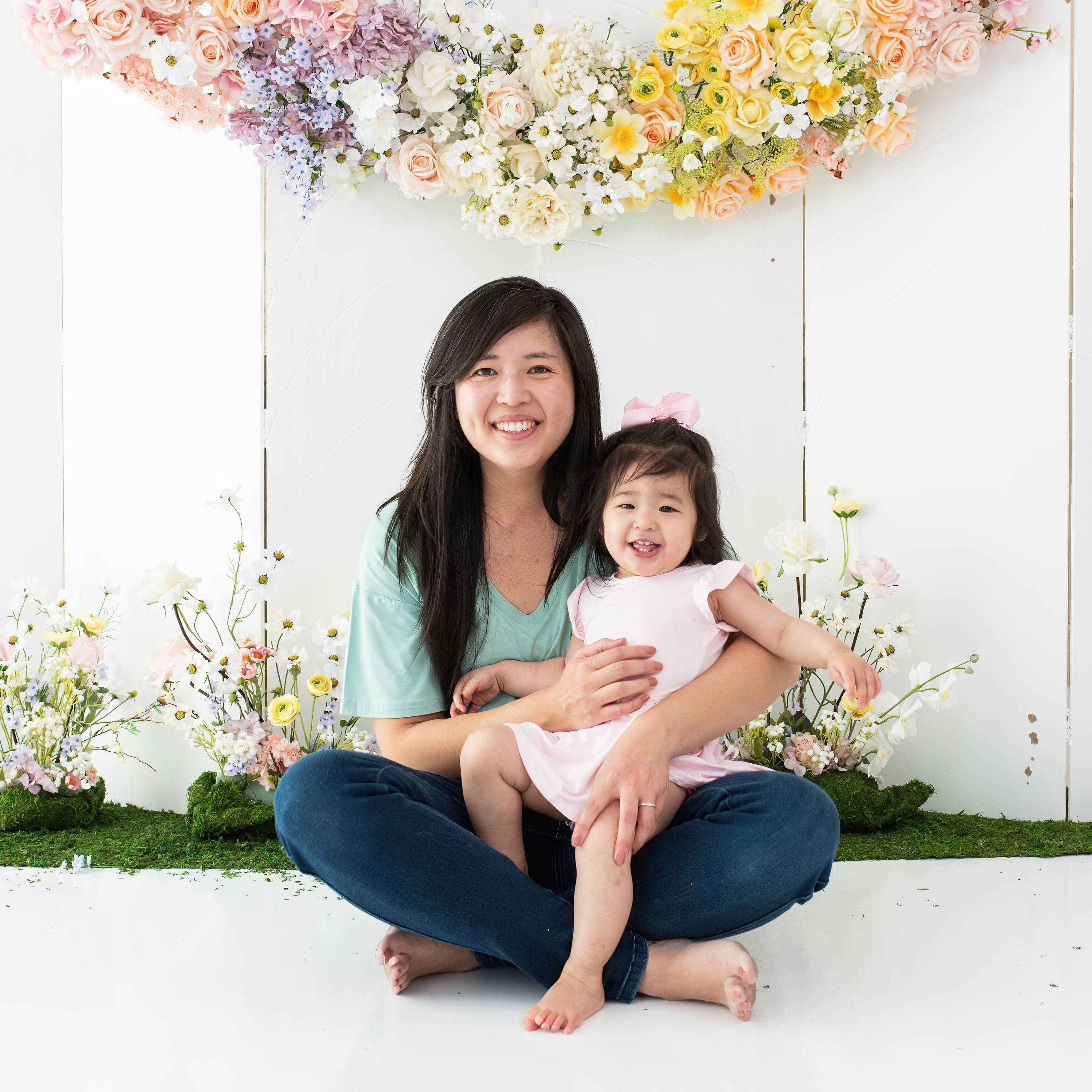 Mom holding toddler wearing Baby wearing Kyte Baby Bodysuit with Twirl Skirt in Sakura