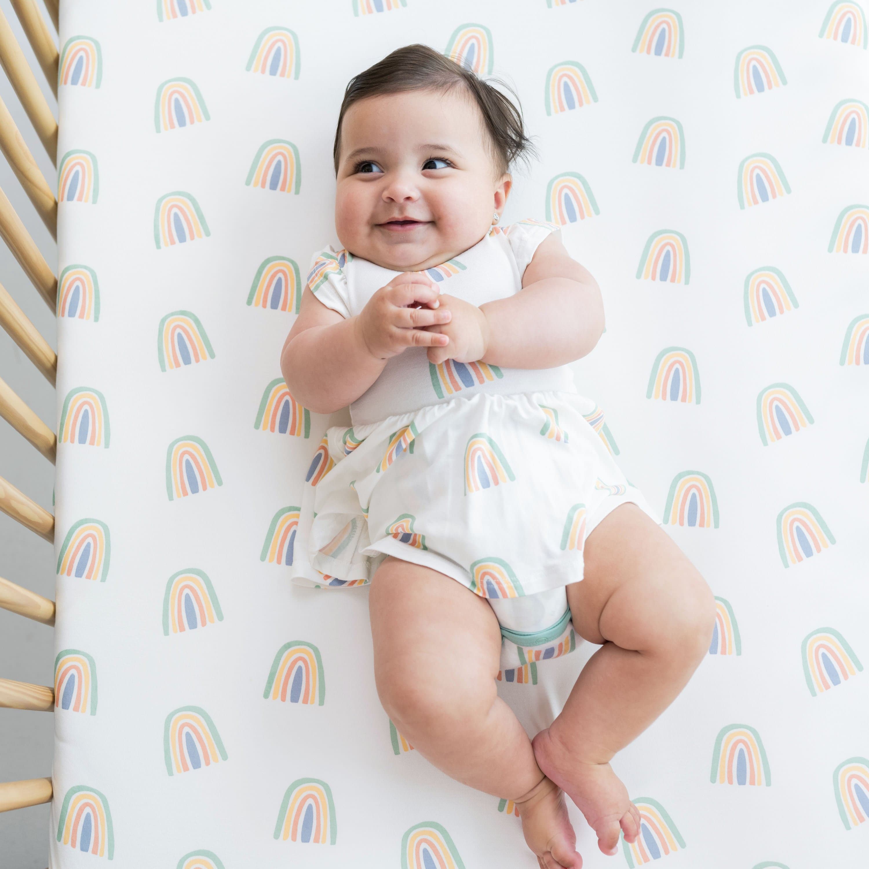 Infant wearing bamboo Kyte Baby Twirl Bodysuit in Wasabi Rainbow