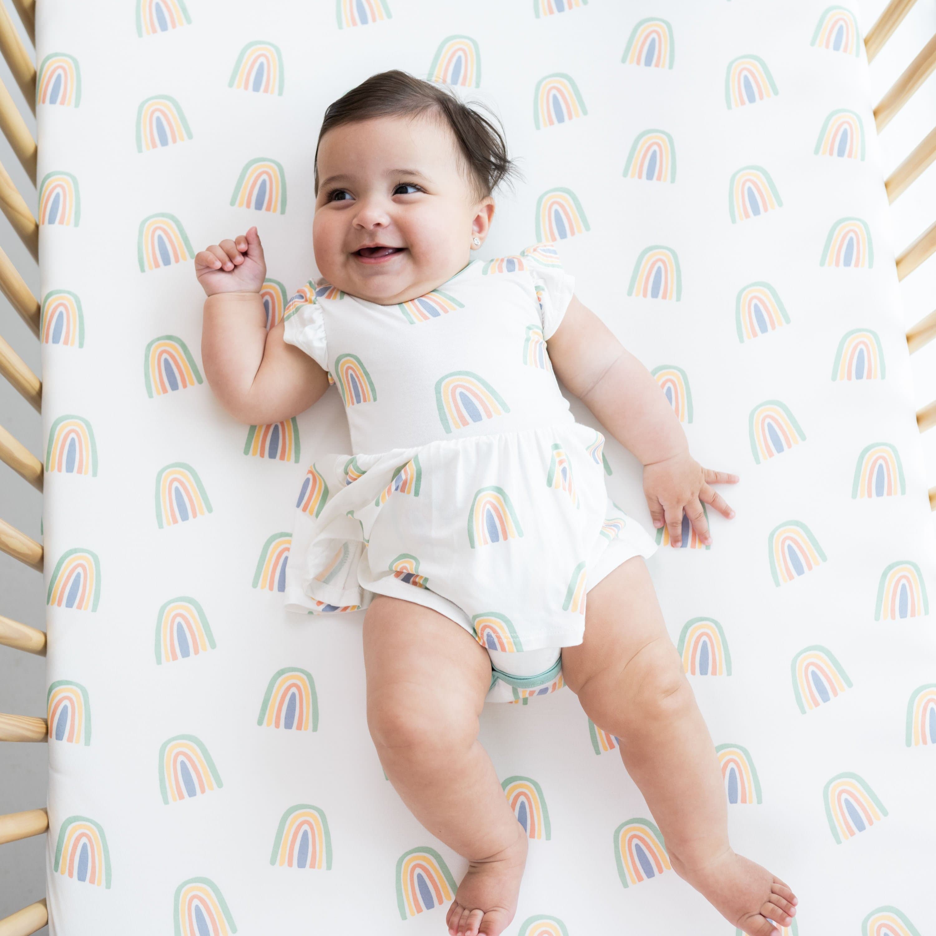 Baby wearing Kyte Baby Bodysuit with Twirl Skirt in Wasabi Rainbow