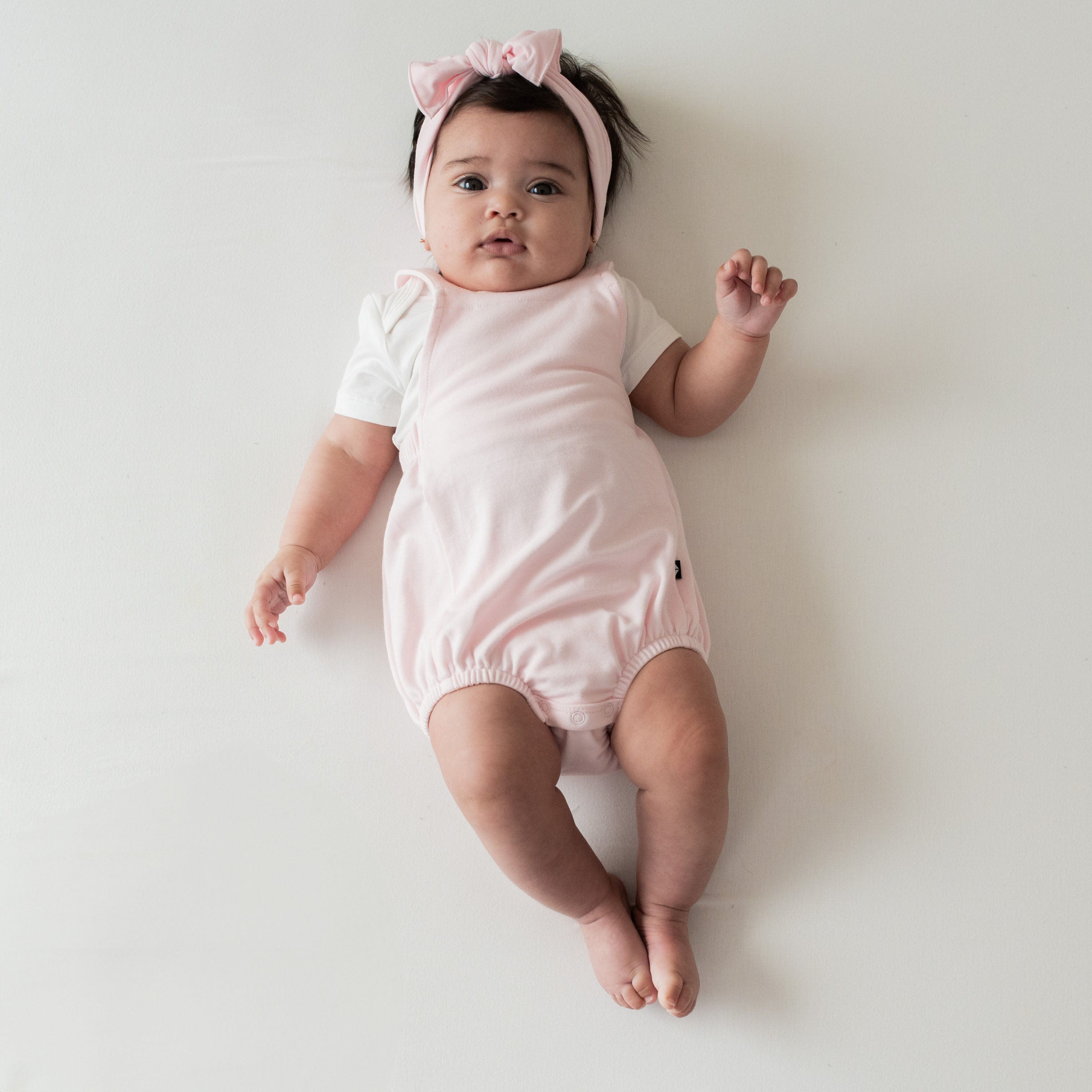 Infant wearing Kyte Baby Bamboo Jersey Bubble Overall in Sakura