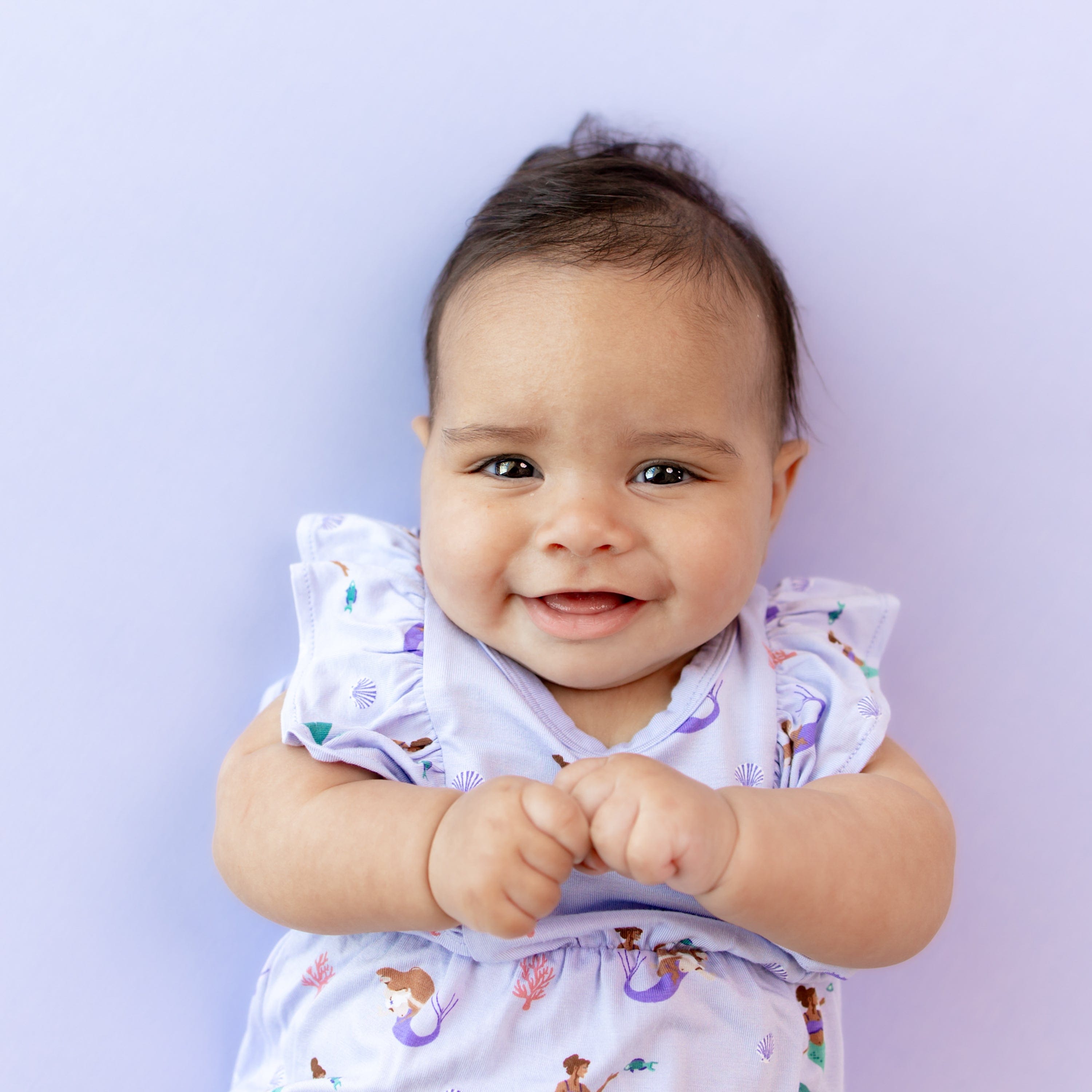 Infant wearing Kyte Baby Bubble Romper with flutter sleeves in Mermaid