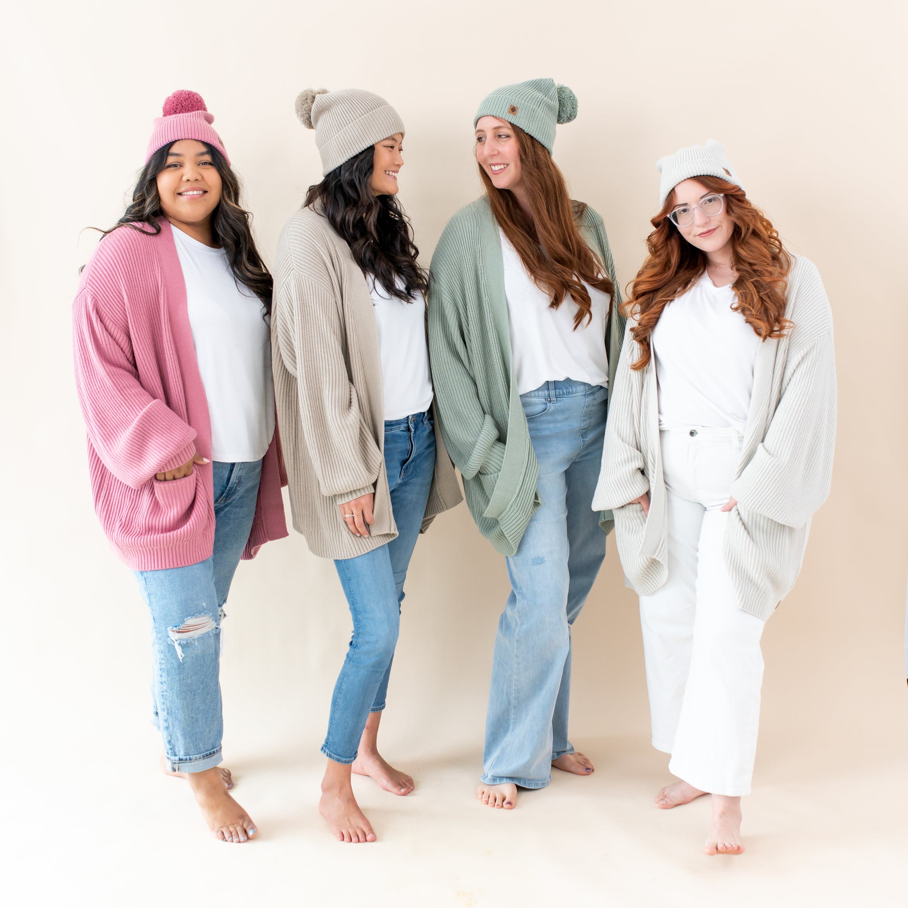 Women wearing Kyte Baby Chunky Knit Adult Pom Beanies in core colors