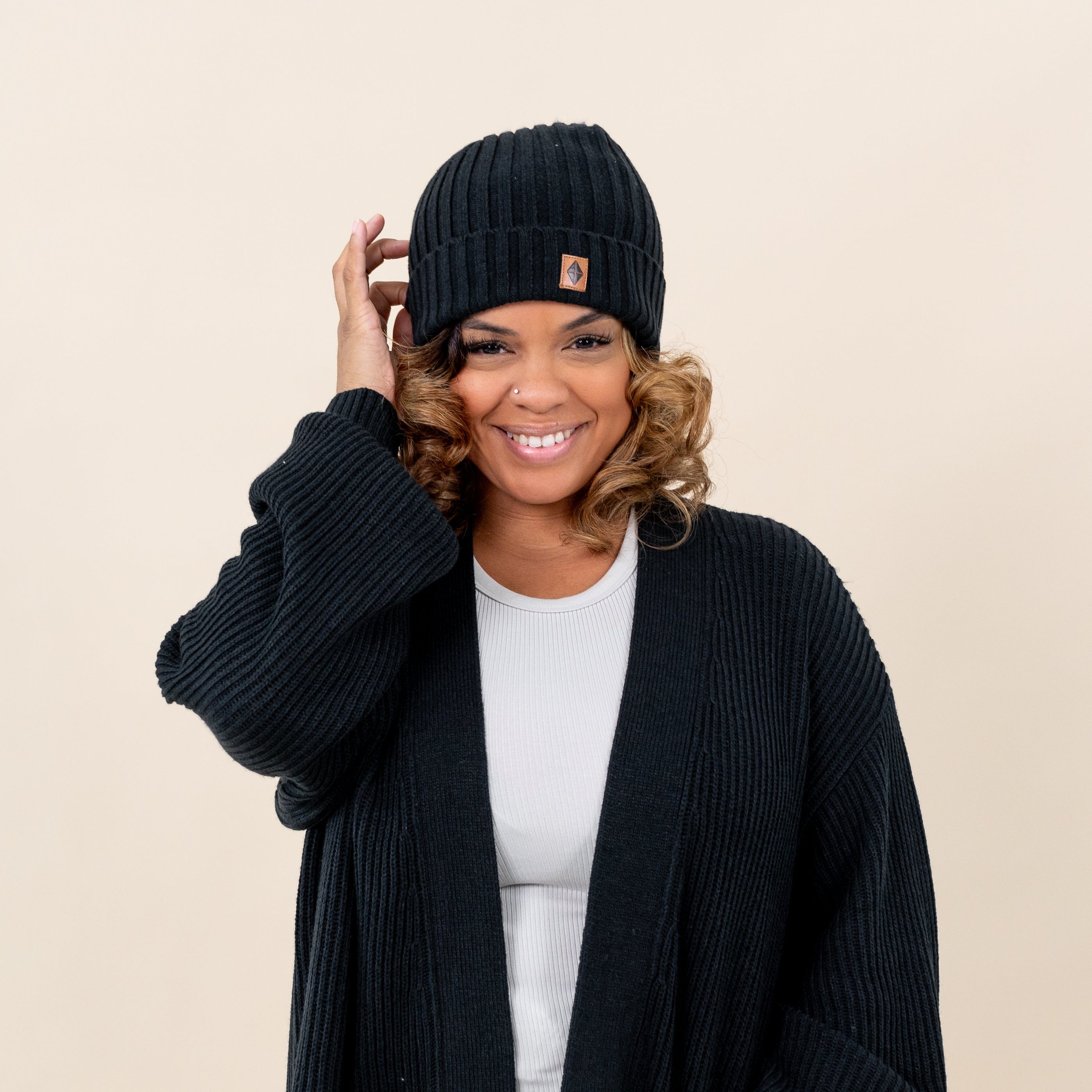 Woman wearing Kyte Baby Chunky Knit Adult Ribbed Beanie in Midnight
