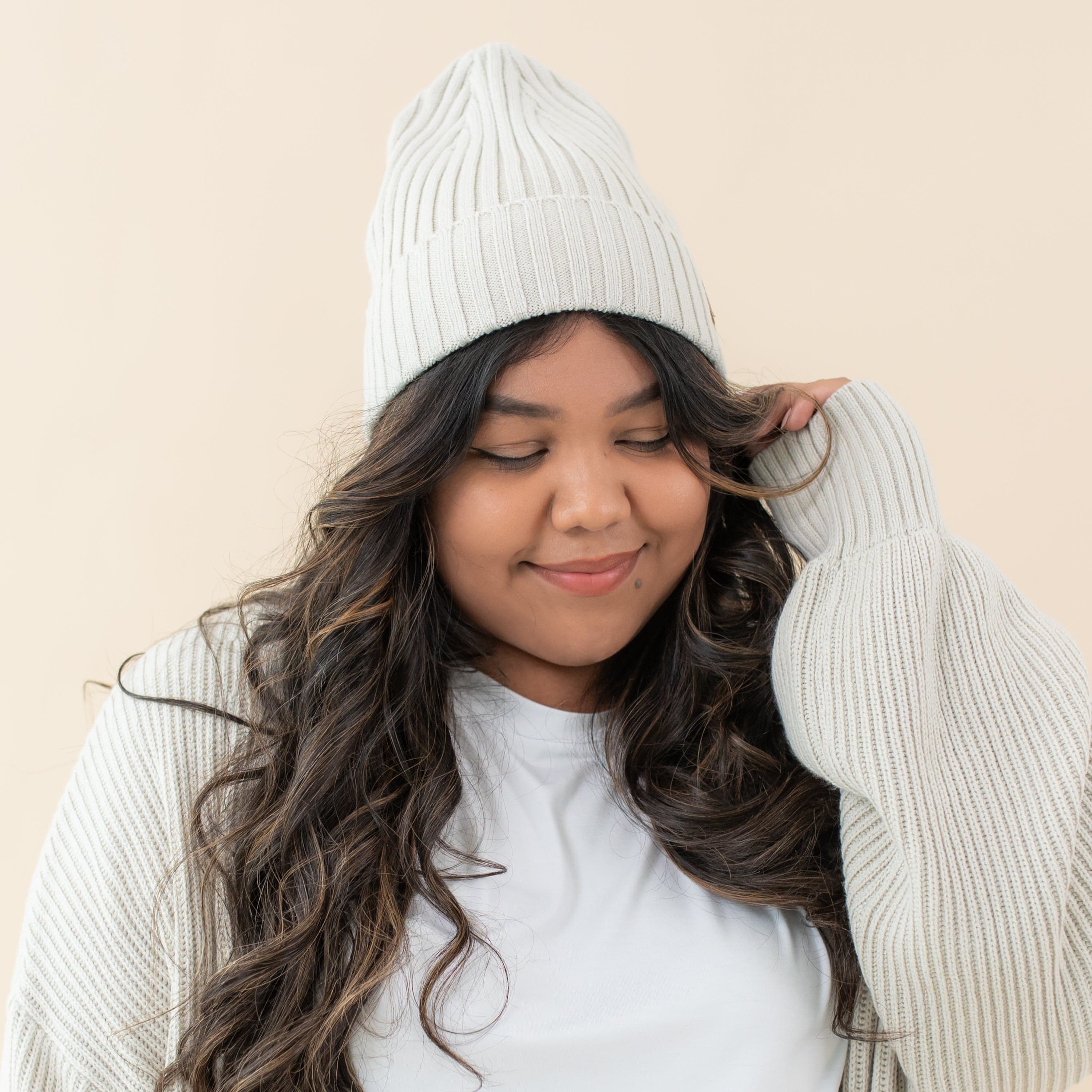 Woman wearing Kyte Baby soft and stretchy Chunky Knit Adult Ribbed Beanie in Oat