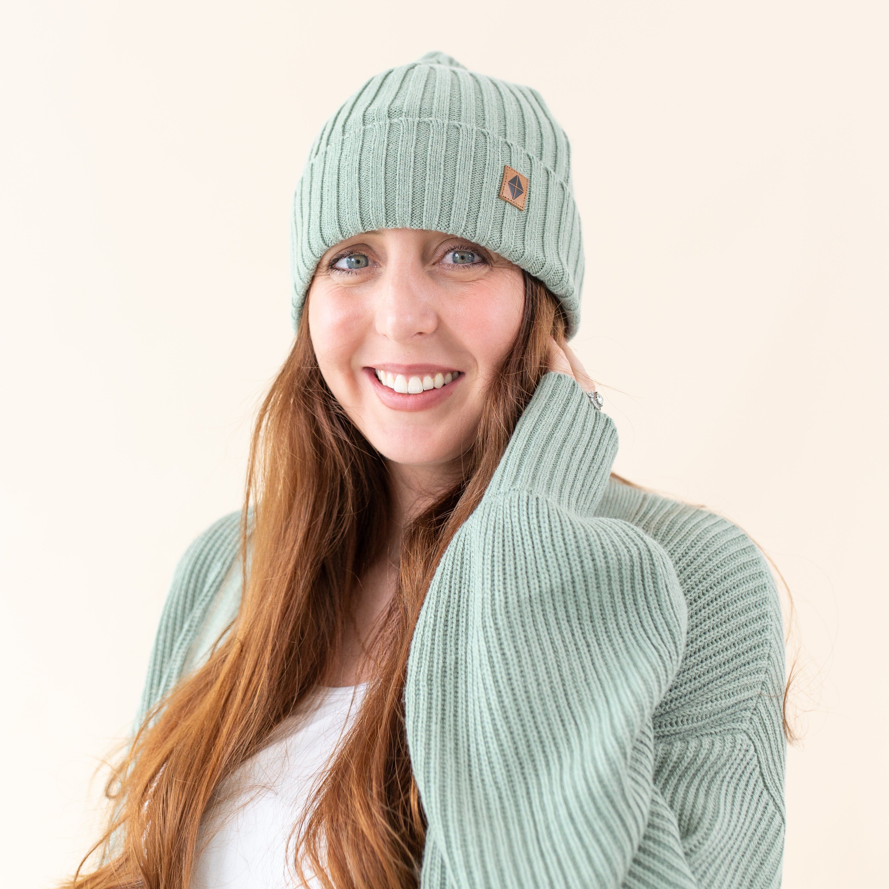 Woman wearing Kyte Baby Chunky Knit Adult Ribbed Beanie in Thyme