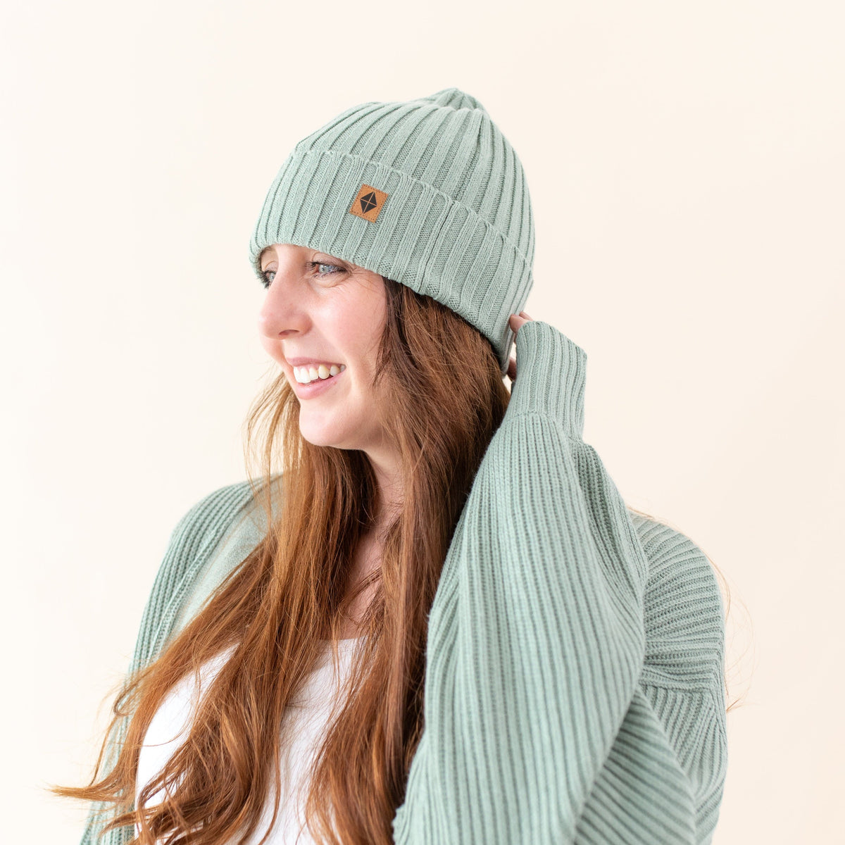 Woman wearing Kyte Baby soft and stretchy Chunky Knit Adult Ribbed Beanie in Thyme